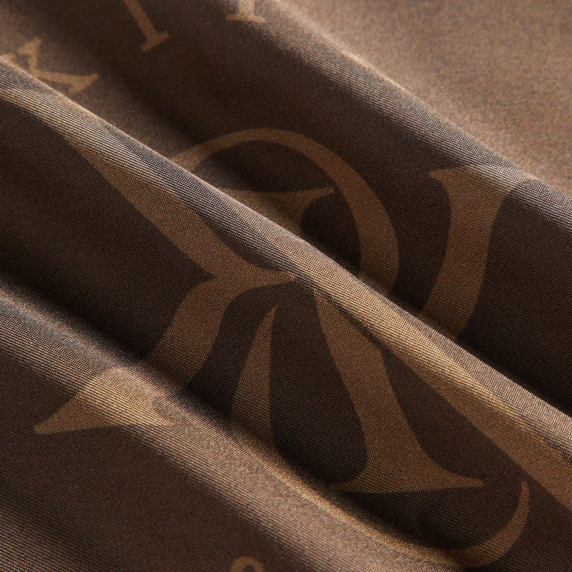 Close-up detail of folded silk fabric texture and print on Kith Rally Scarf in Auberge