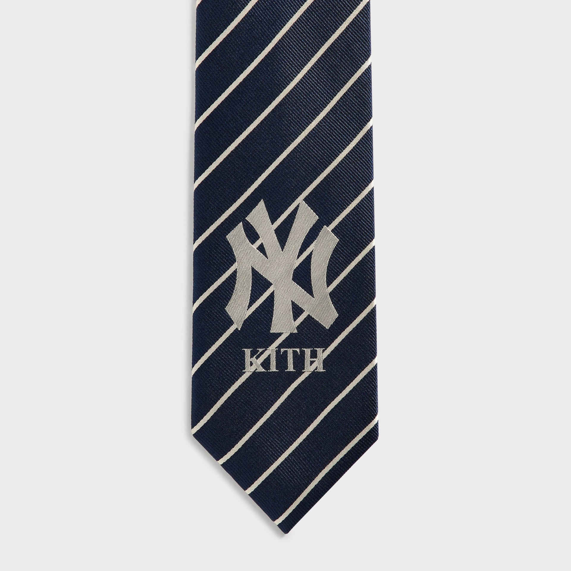 Close-up of NY logo and KITH wordmark on Nocturnal navy pinstripe silk tie