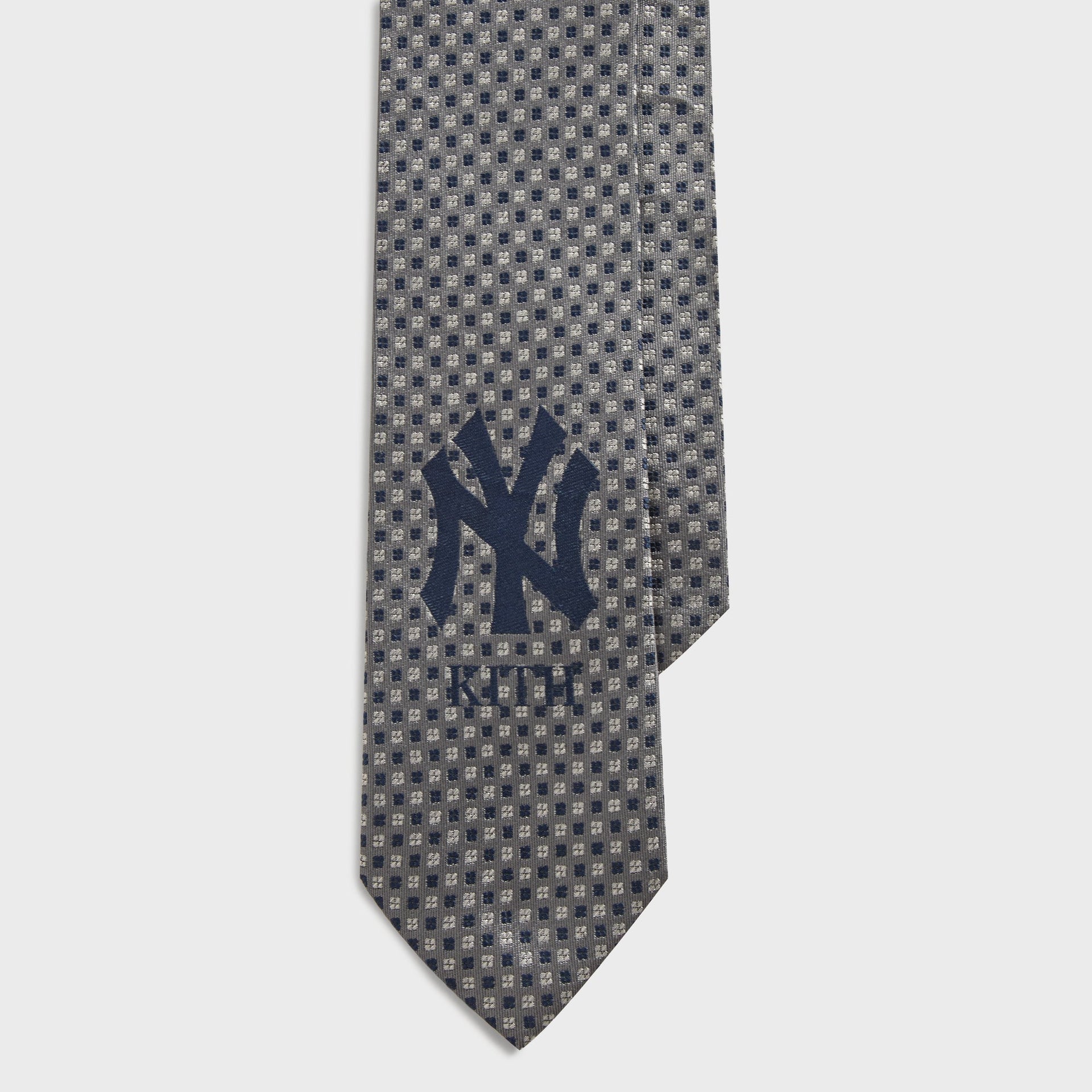 Close-up of NY Kith logo on Skyscraper foulard tie with grey dot weave pattern
