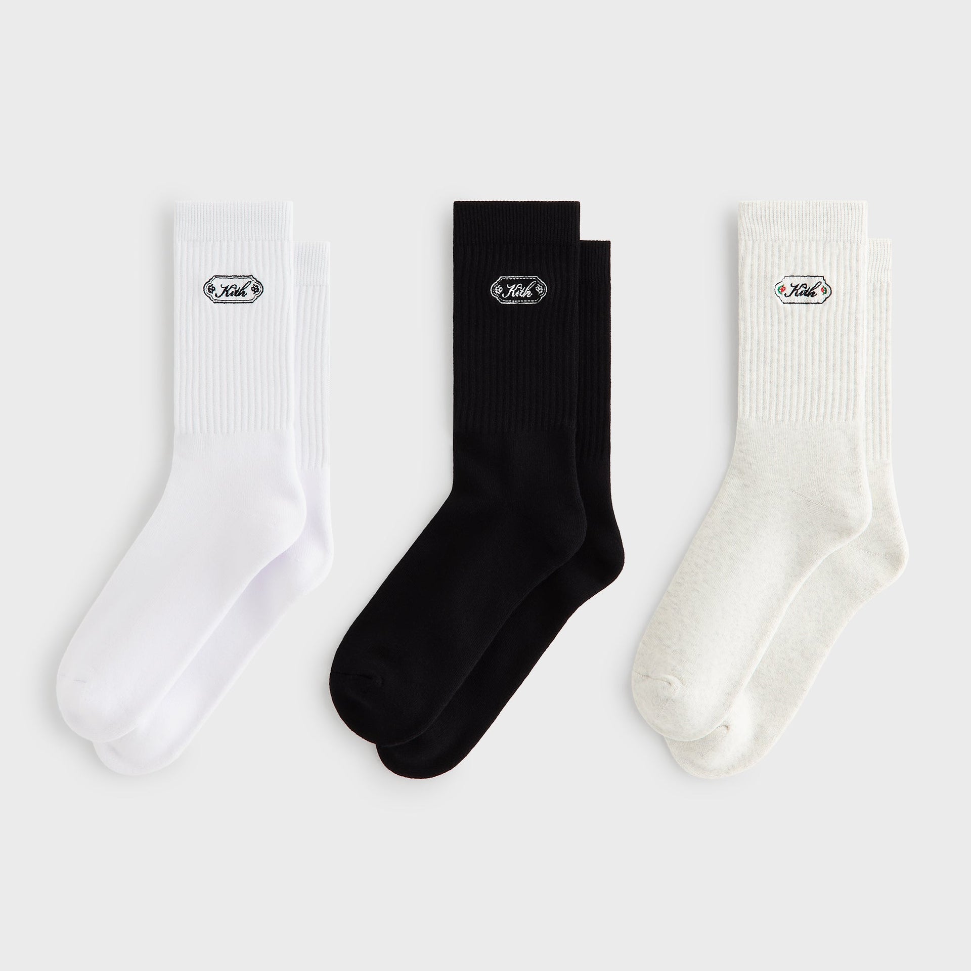 Kith 3-Pack Script Plaque Crew Socks in Multi, flat lay showing white, black, and oatmeal pairs with logo