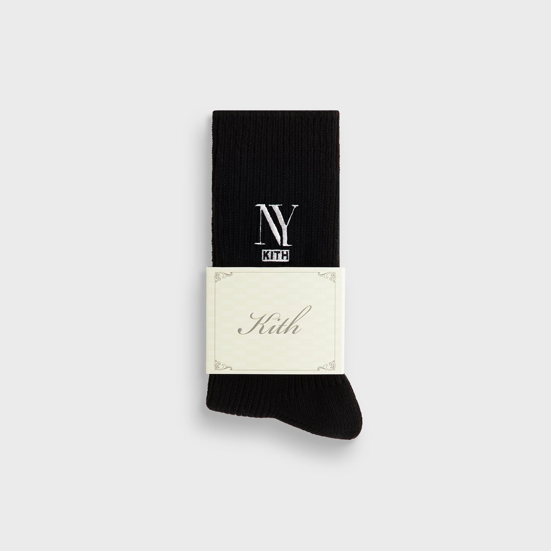 Folded black Kith NY Cotton Slouchy Crew Sock with branded cream paper wrap band reading Kith