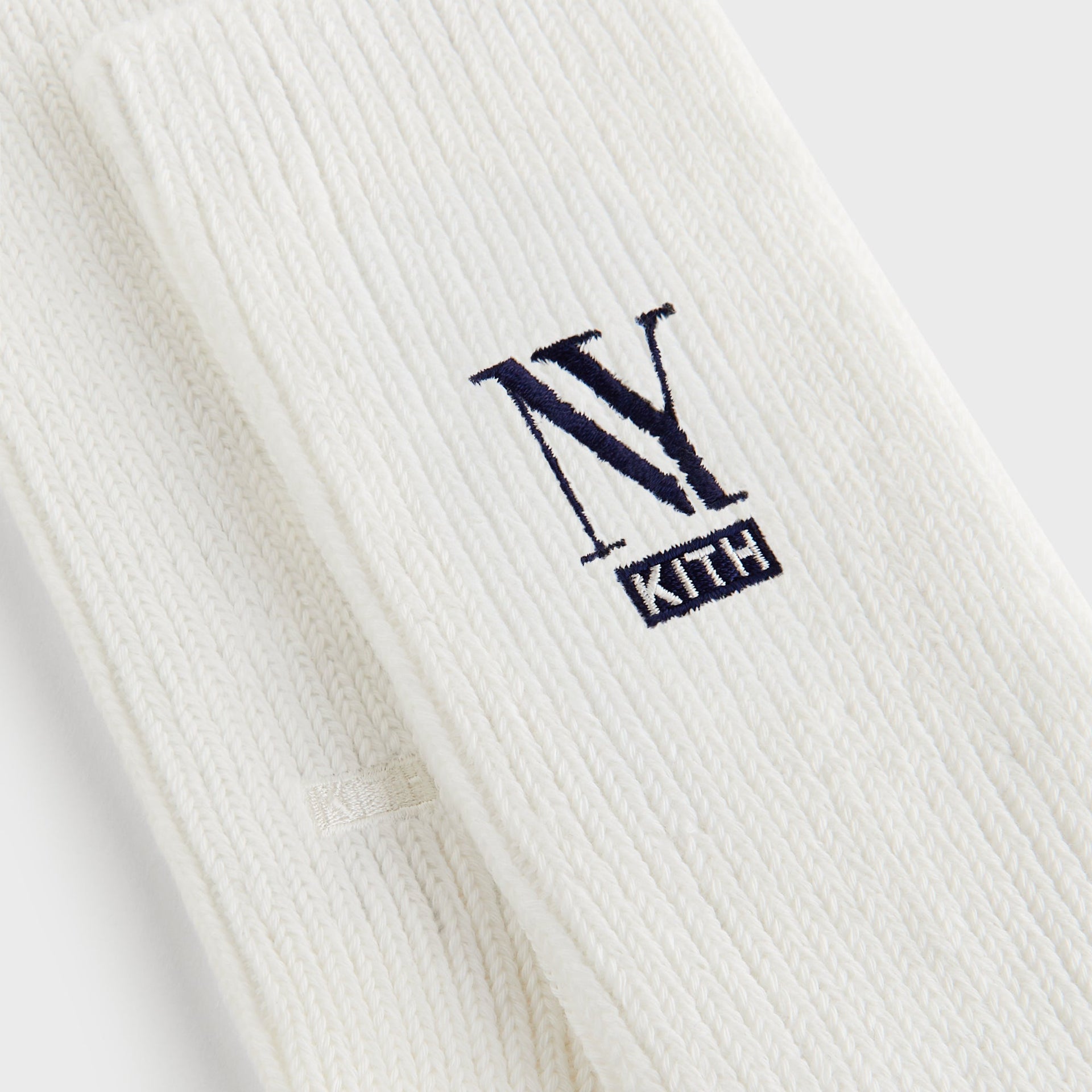 Close-up of the ribbed knit cuff and embroidered NY Kith logo on Kith NY Cotton Slouchy Crew Socks in Silk