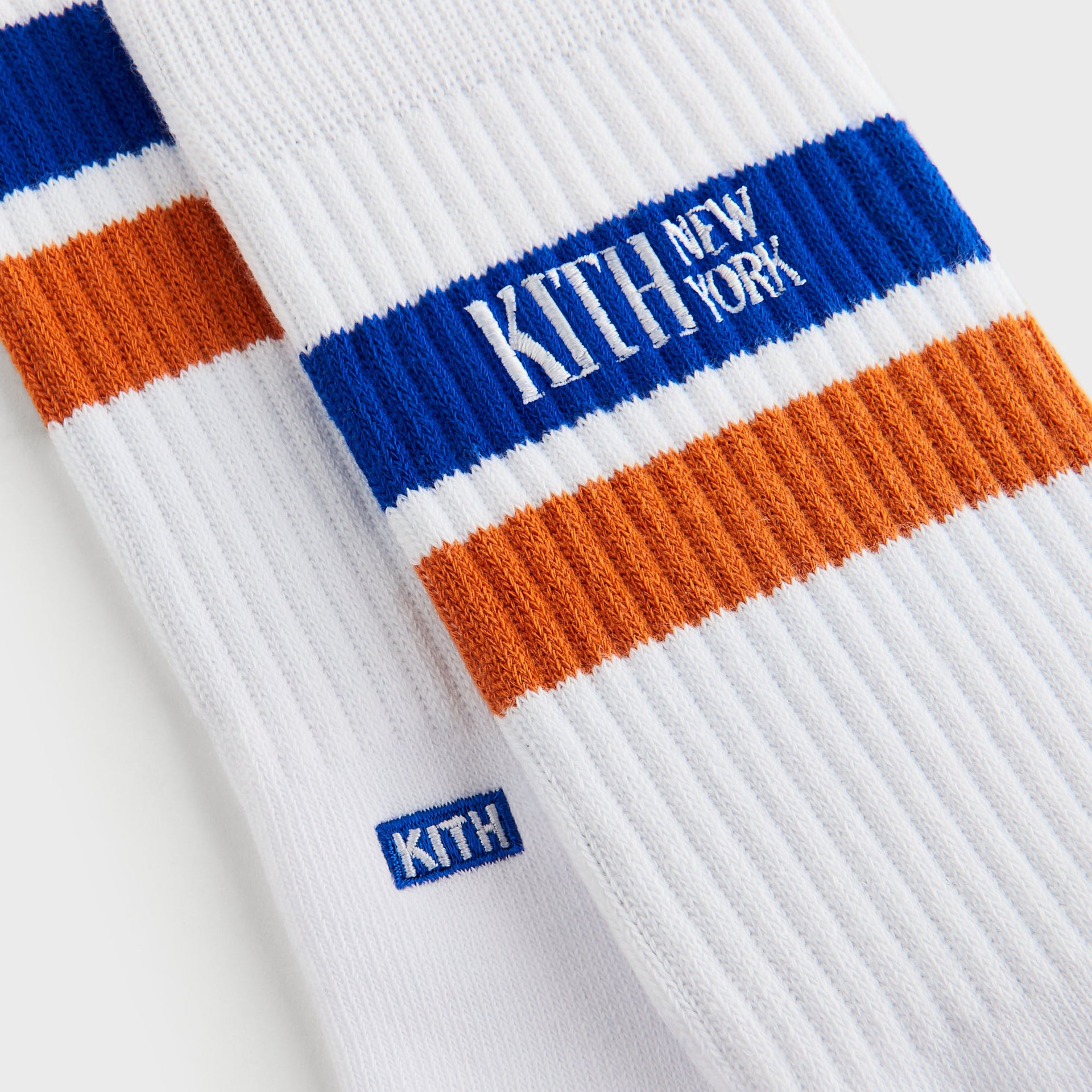Close-up of blue and orange stripe detail and small woven Kith New York tab on the Calf Stripe Socks