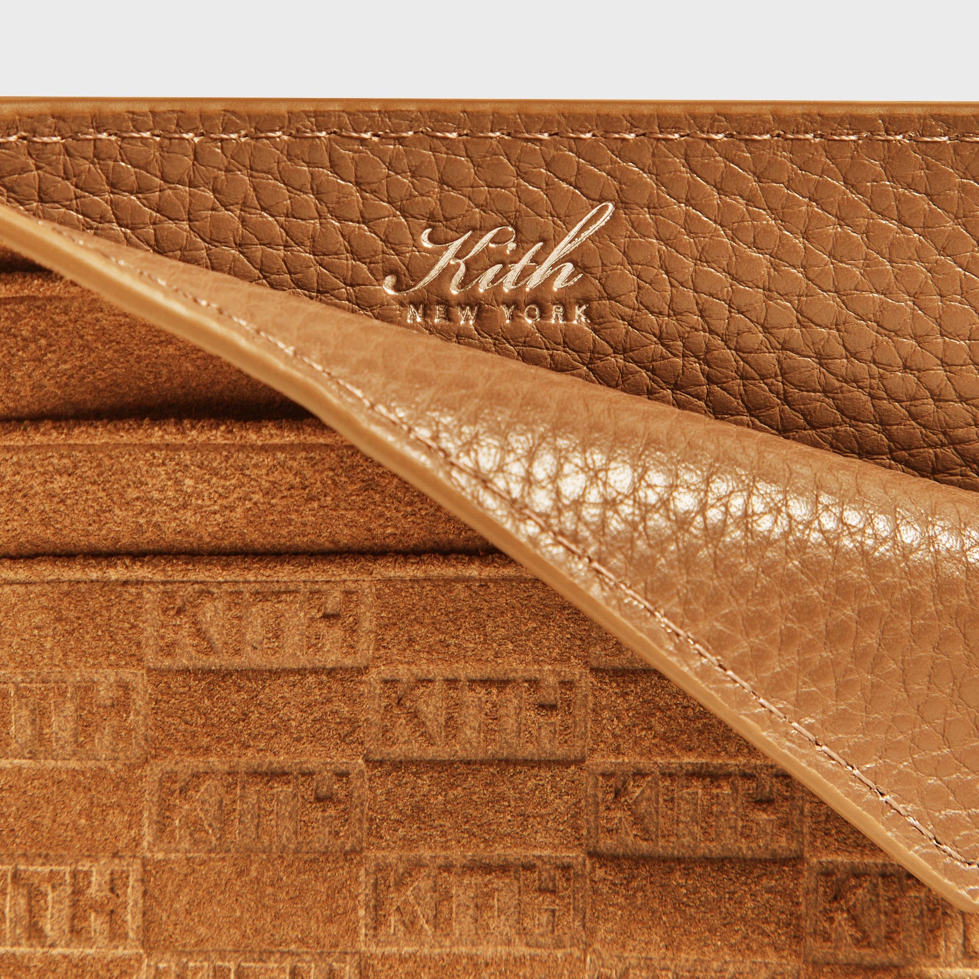 Macro close-up of the smooth leather interior panel with gold-foil Kith New York stamp inside the cardholder