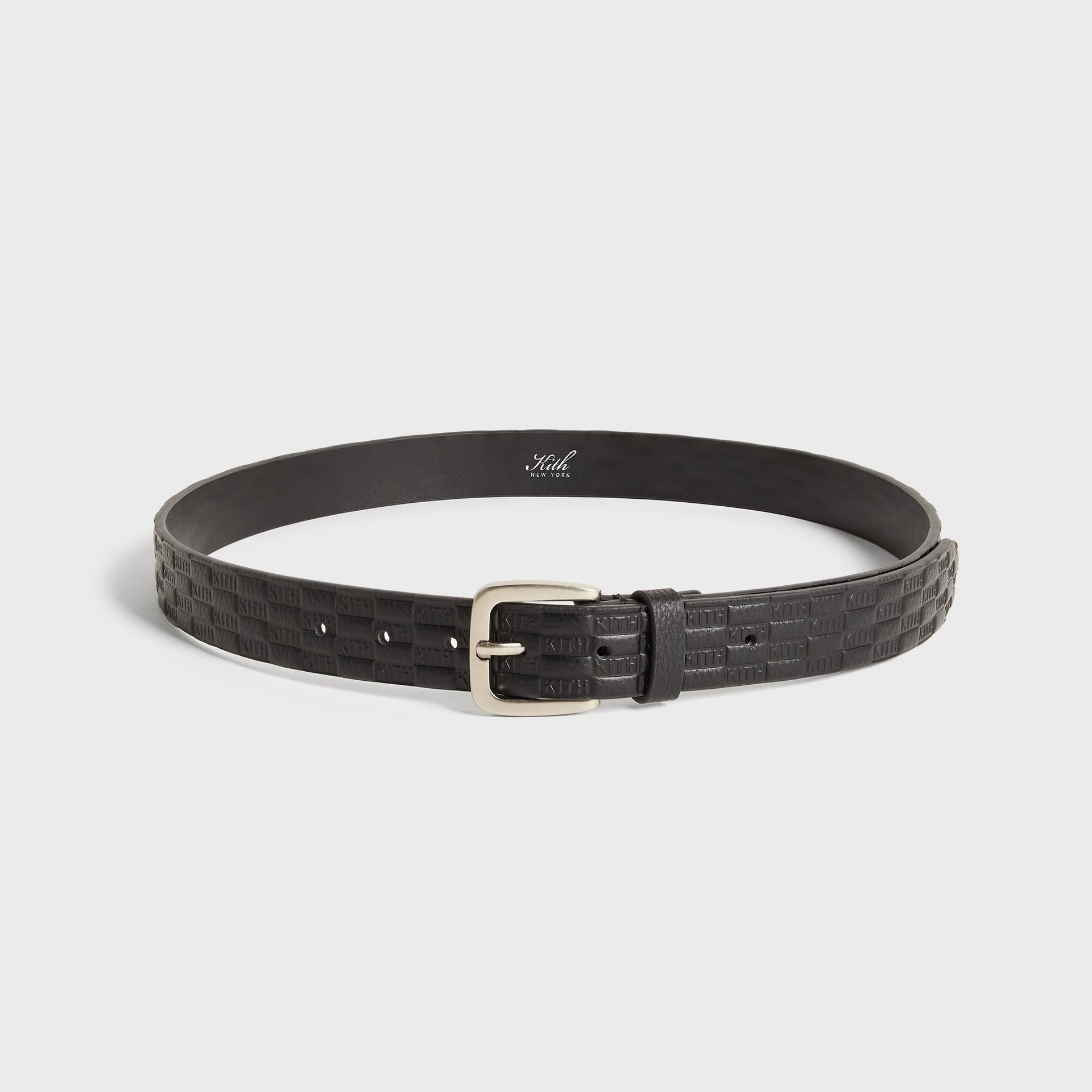 Kith Monogram Tumbled Leather Belt in Black, full coiled view showing silver buckle and embossed KITH pattern