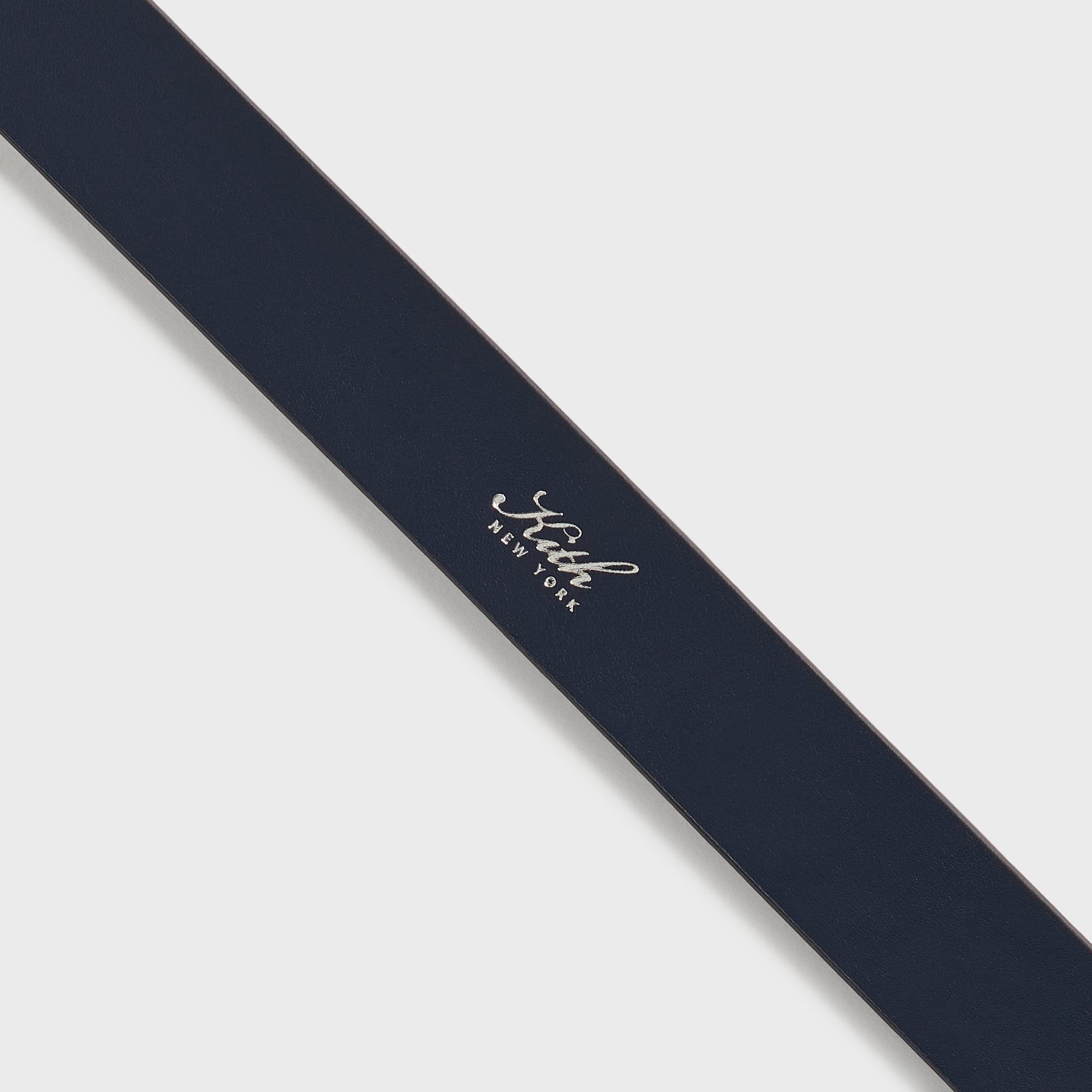 Kith Monogram Tumbled Leather Belt in Ink, macro detail of foil-stamped Kith New York logo on strap