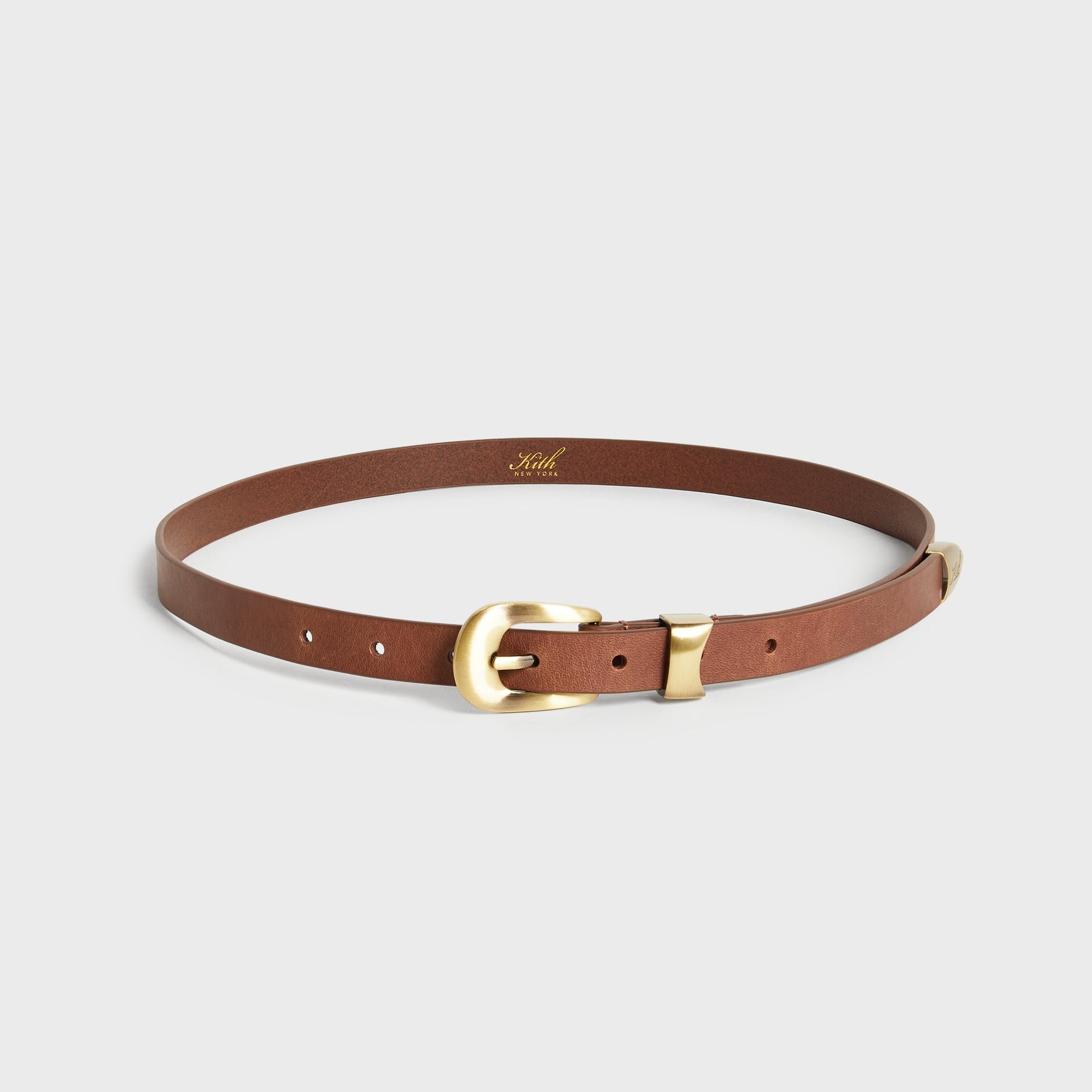 Kith Western Smooth Leather Belt in cognac brown with brass horseshoe buckle, coiled full view with gold Kith New York stamp