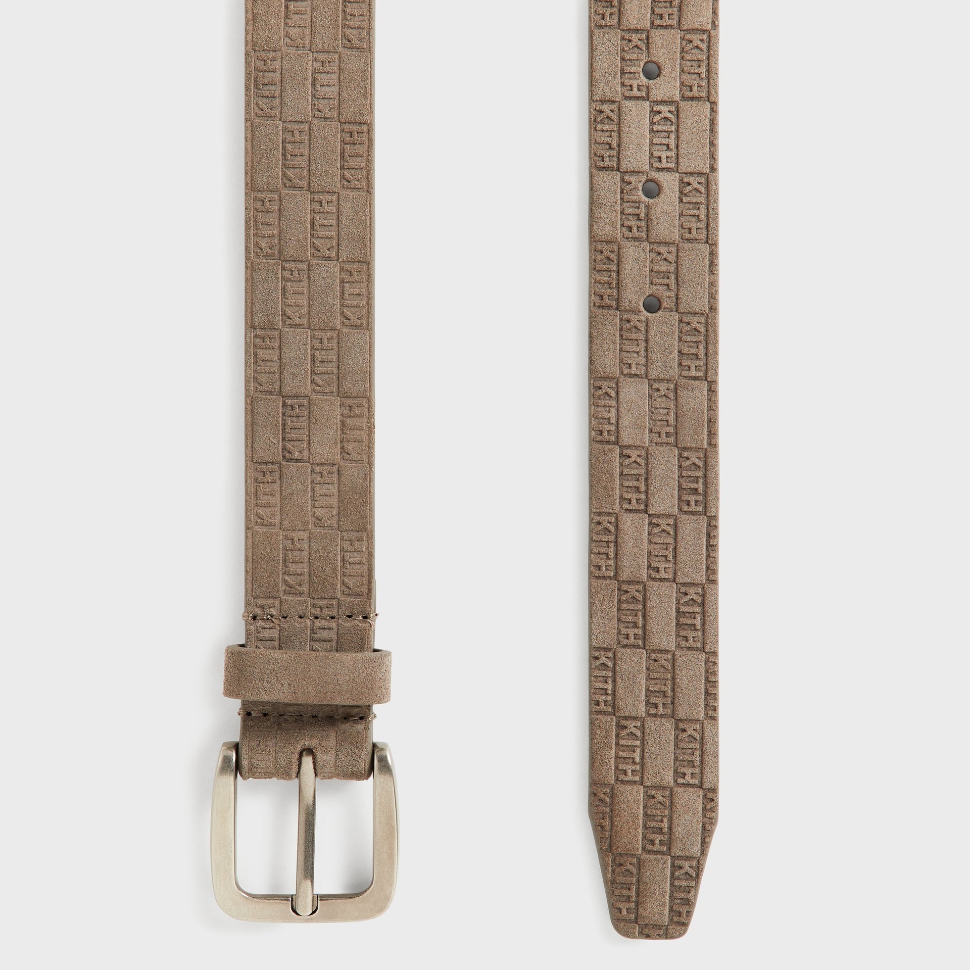 Kith Monogram Suede Belt in Java, close-up angled view of the silver buckle and keeper loop with embossed KITH texture