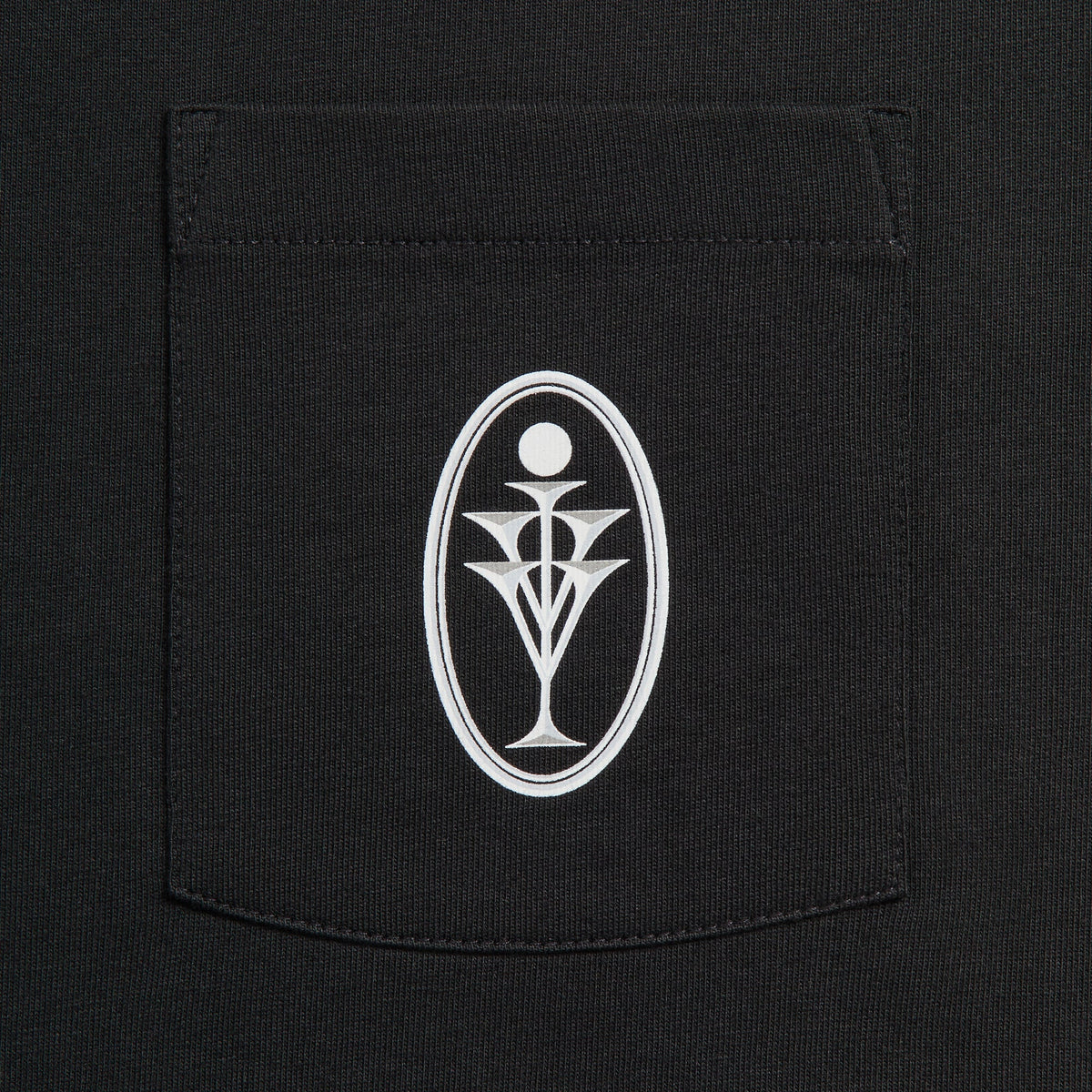Close-up of black pocket with white oval goblet emblem on Kith Ivy for Cafe Mogador Pocket Tee