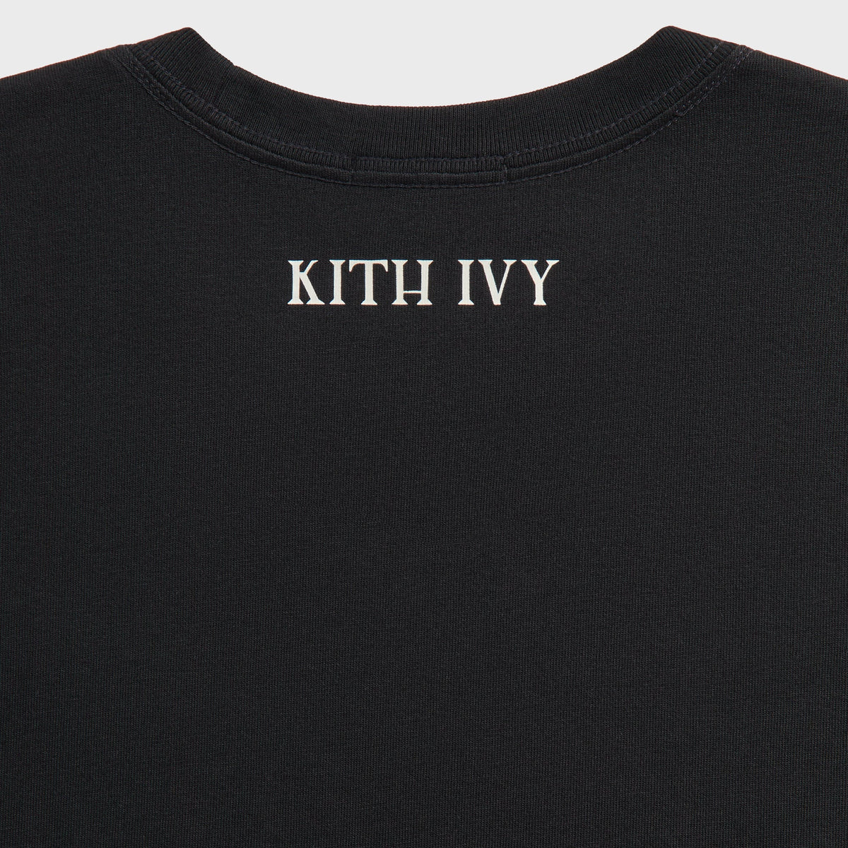 Close-up of cream KITH IVY text print at back neck of black Kith Ivy Tee