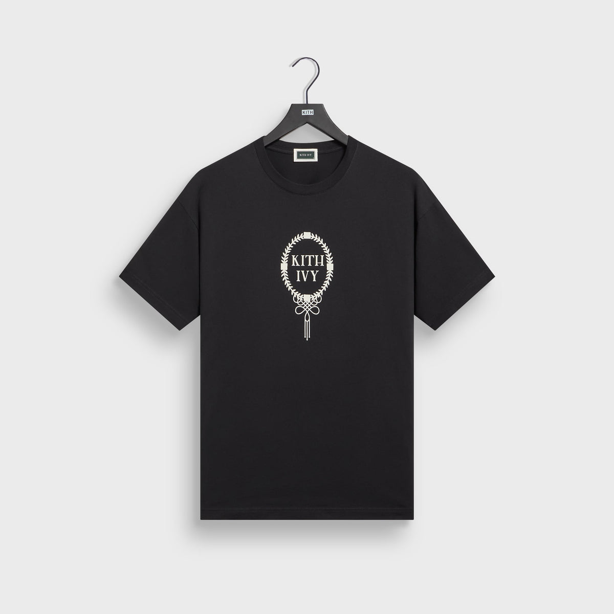 Kith Ivy Tee in black on hanger, front view with cream laurel-wreath KITH IVY emblem on chest