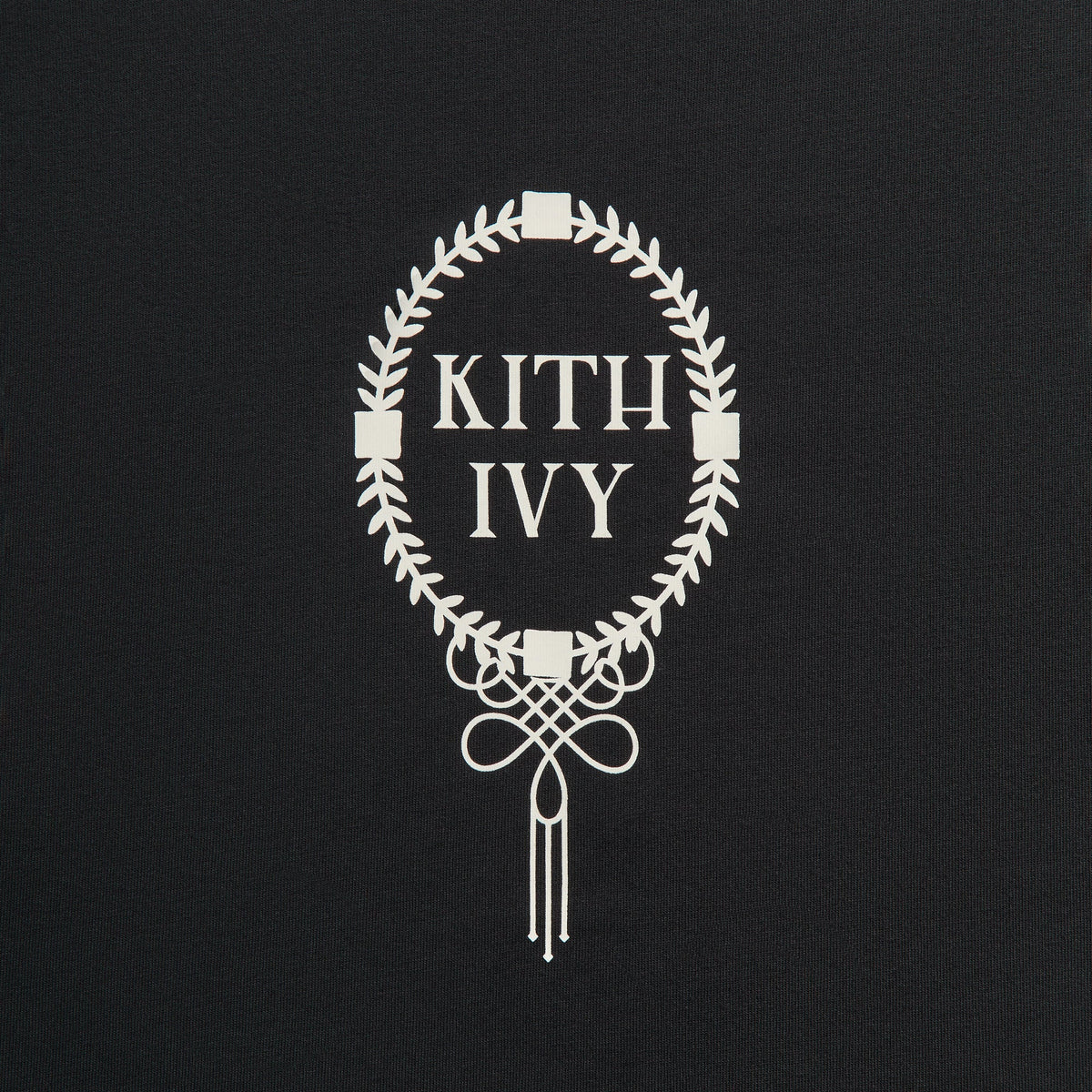 Close-up of cream KITH IVY laurel wreath crest graphic with knot tassel on black Kith Ivy Tee