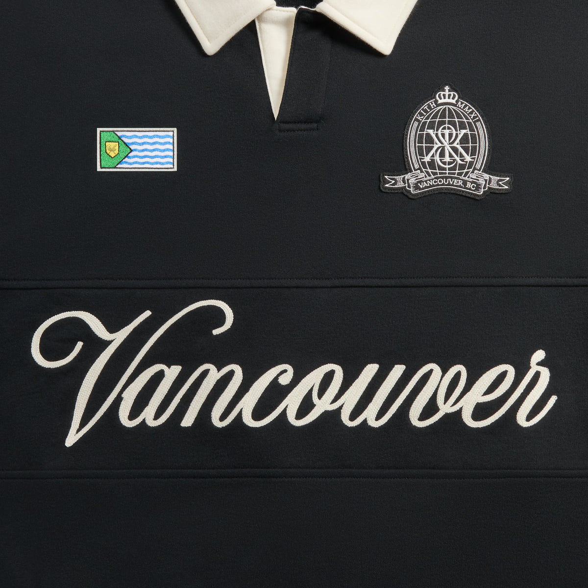 Close-up of Vancouver script embroidery, city flag patch and crest patch on the black Kith Nelson rugby