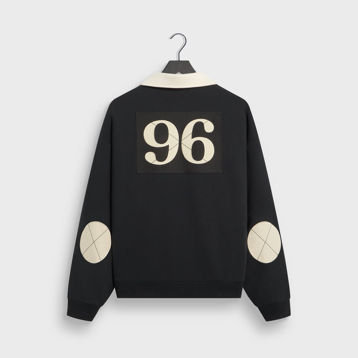 Kith Vancouver Nelson rugby in black, back view with cream 96 appliqué patch and cream elbow patches on hanger