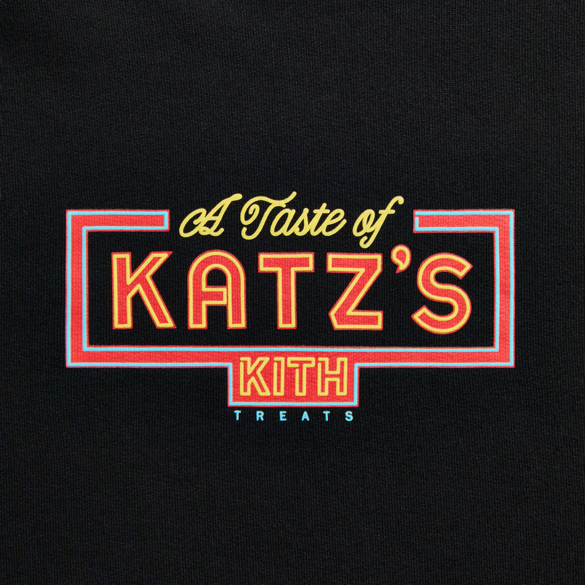Close-up of red, yellow and blue neon-sign-style 'A Taste of Katz's' Kith Treats graphic on black hoodie chest