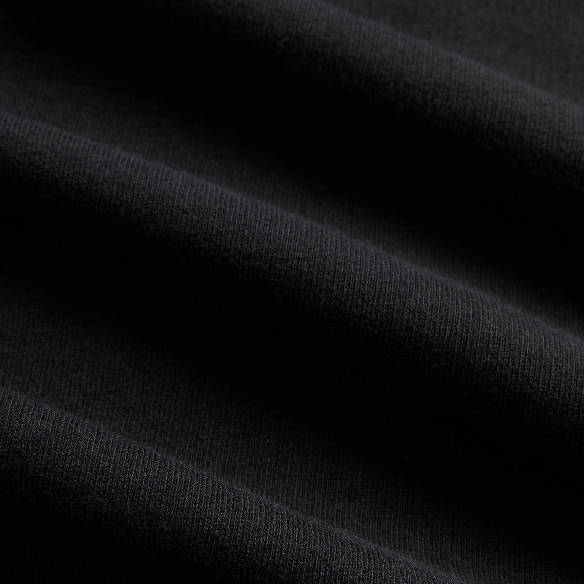 Macro detail of black cotton fleece fabric texture on Kith Treats for Katz's Delicatessen hoodie