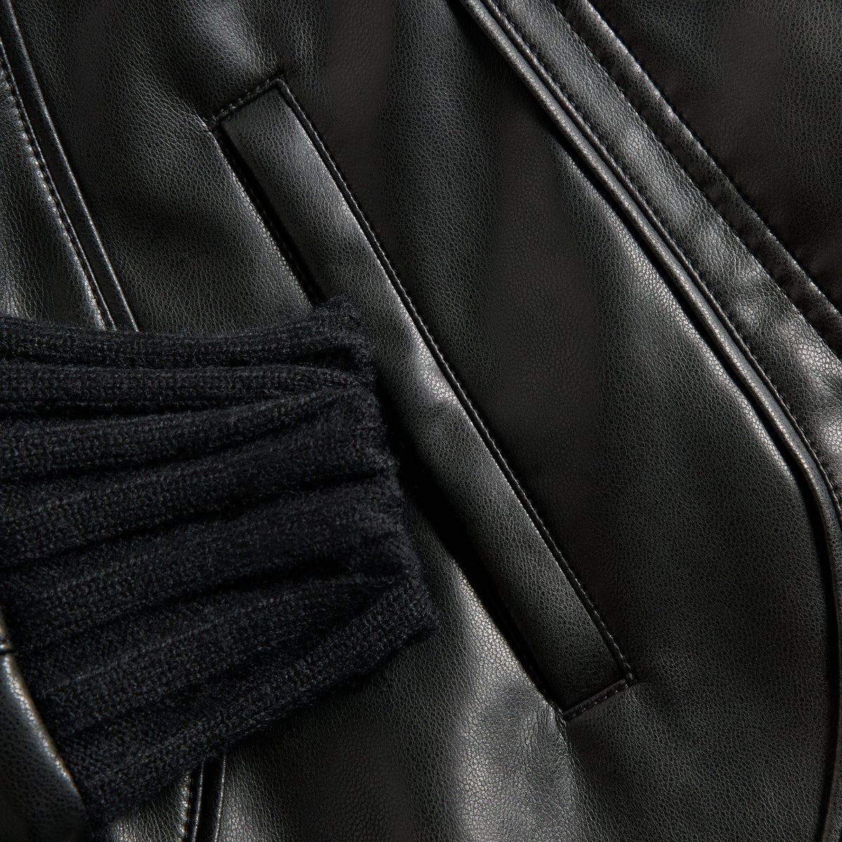 Close-up of the rib-knit cuff and welt pocket on the Kith Women Syd faux leather Harrington jacket