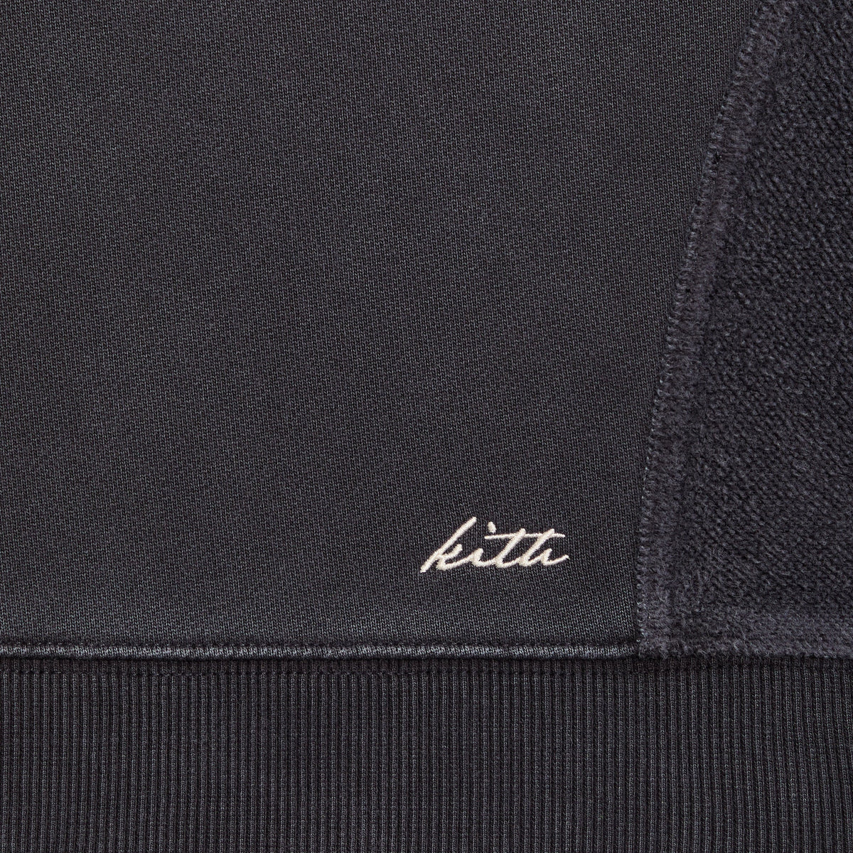 Close-up of the hem and embroidered Kith script logo on the Elvina paneled hoodie