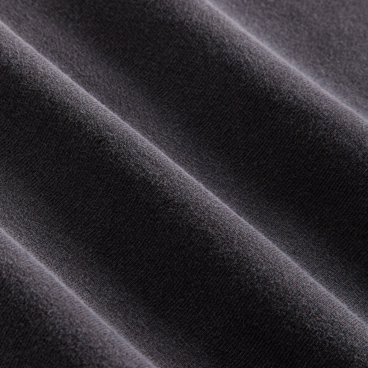 Close-up of the faded black fleece fabric texture on the Kith Women Opal moto top