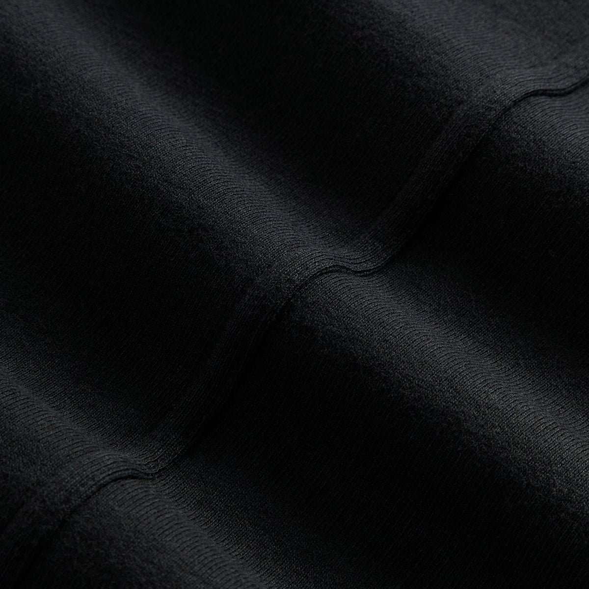 Close-up of the black fleece fabric texture on the Kith Women Evie moto paneled jacket