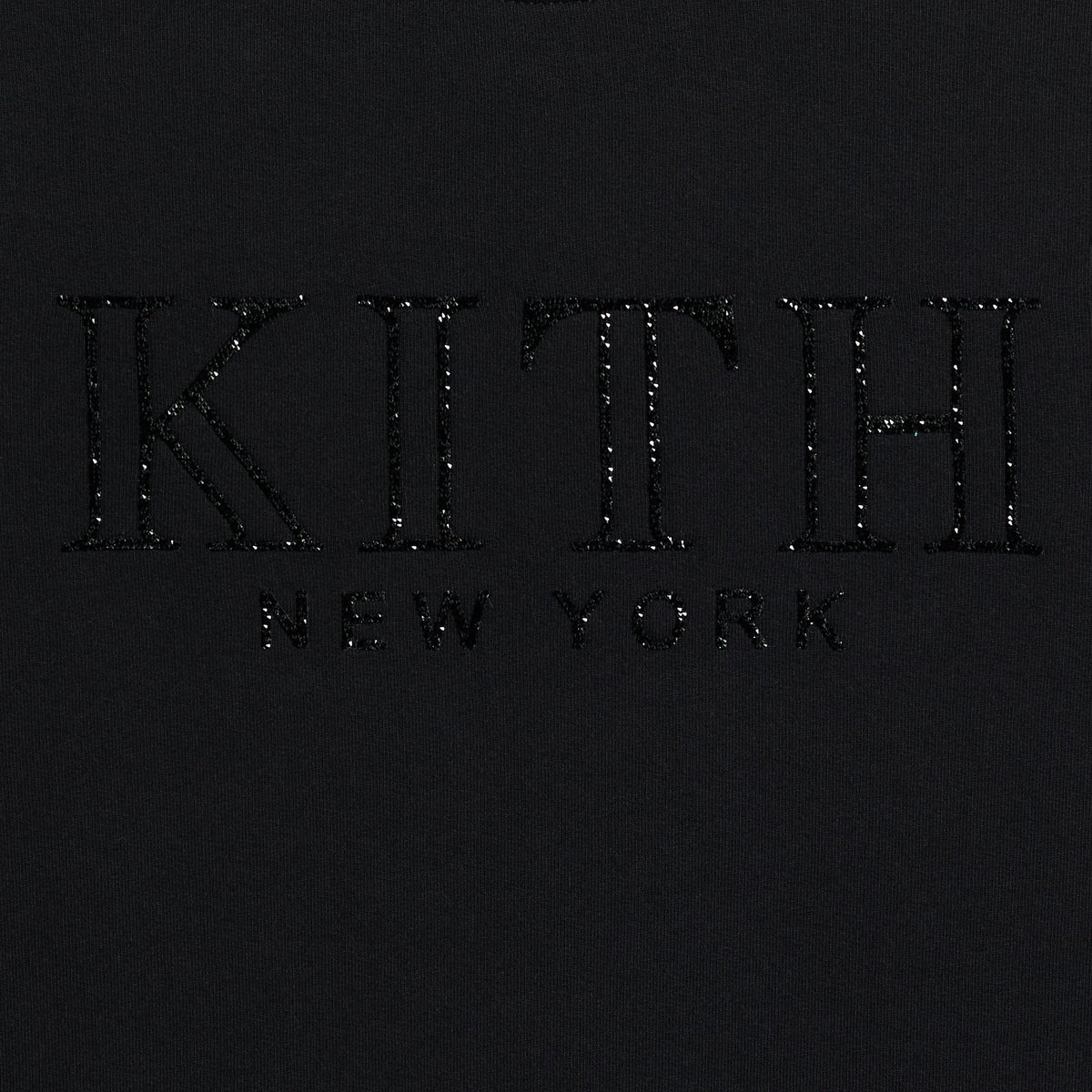 Close-up of the crystal-embellished Kith New York serif logo on the Ashwin crewneck in black