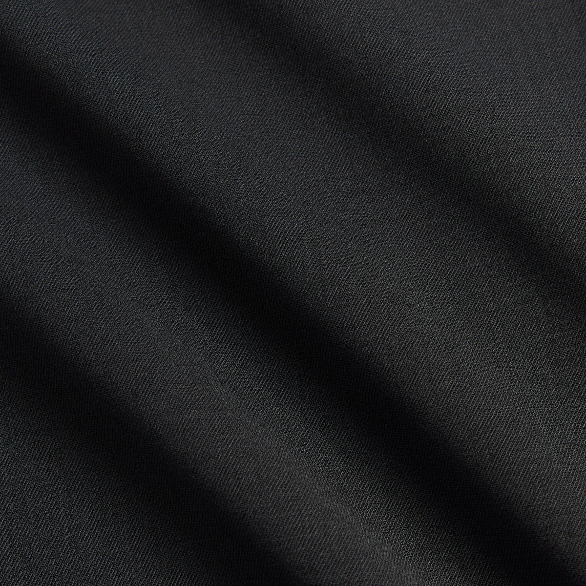 Close-up of the black twill fabric texture on the Kith Women Tallis suiting trouser