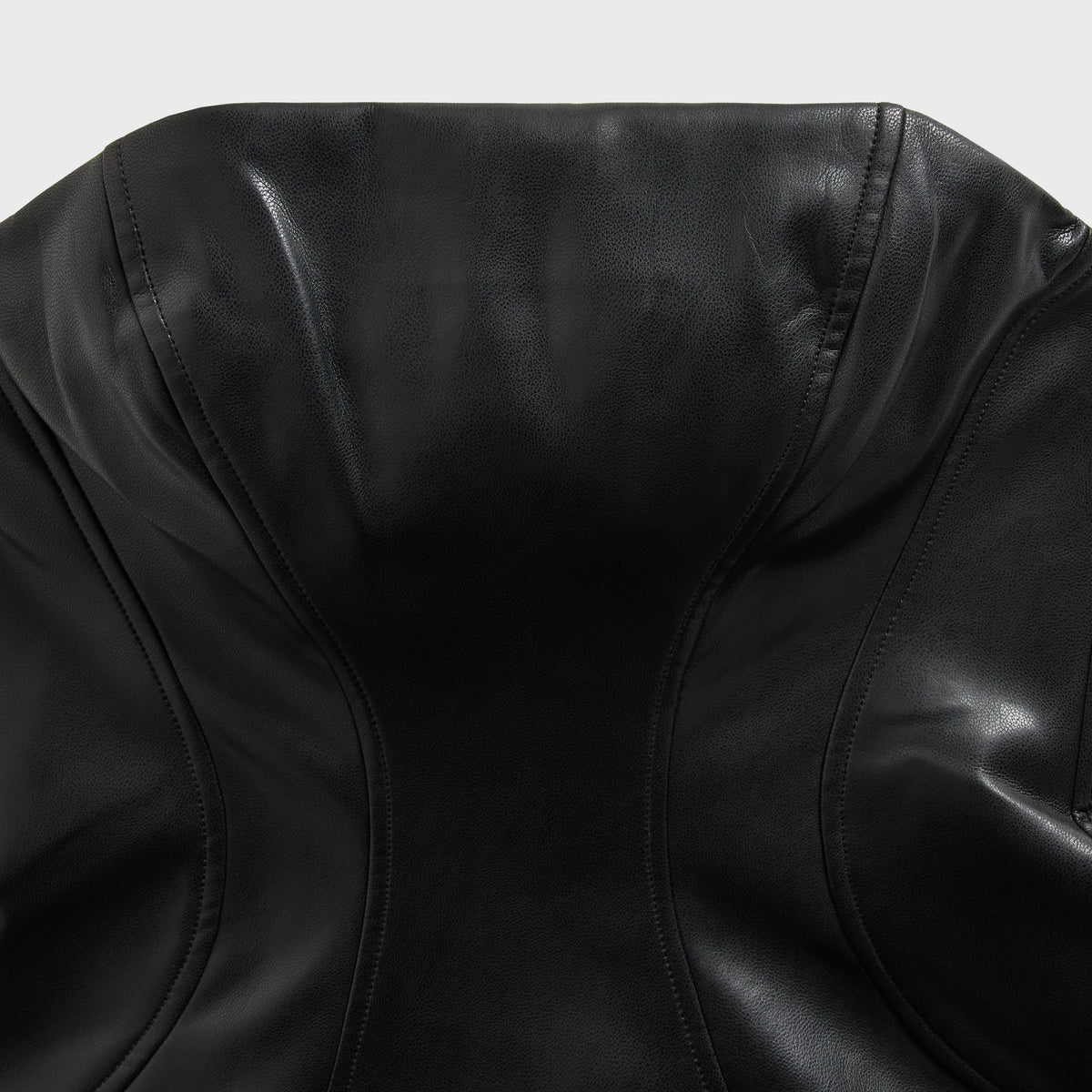 Close-up of the bustier paneling and stitching on the Kith Saja faux leather mini dress in black