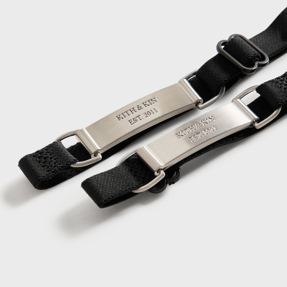 Close-up of the silver 'Kith & Kin Est. 2011' engraved garter clip hardware on the black Sheer Garter Belt Socks