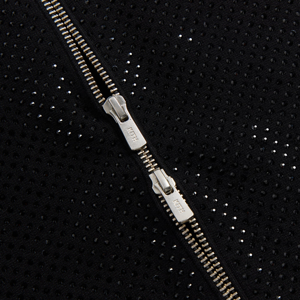 Close-up of the double zip pulls engraved with Kith on the Ina II studded track jacket