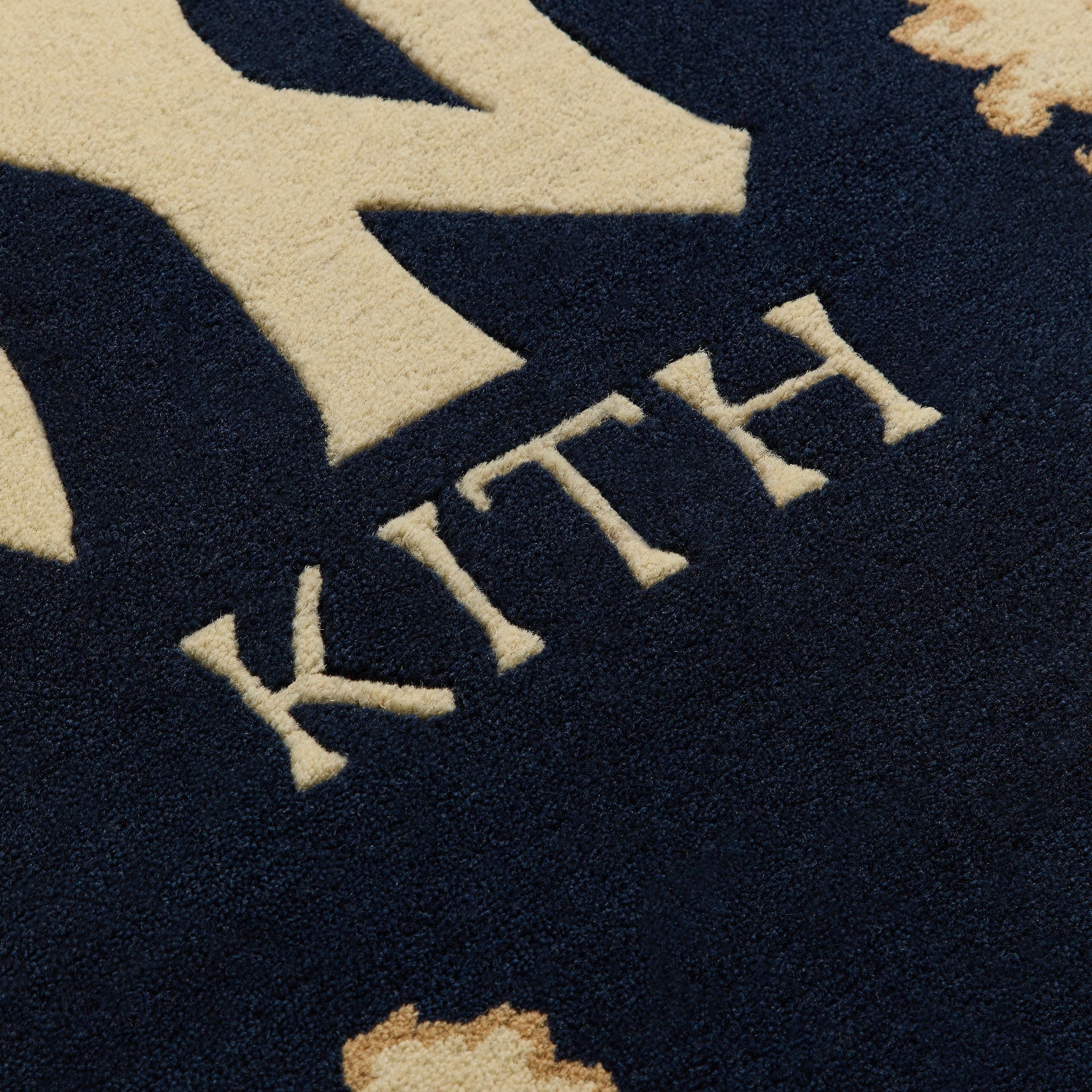 Macro detail of wool pile texture on KITH lettering, Multi colorway Kith x Yankees hand-knotted rug