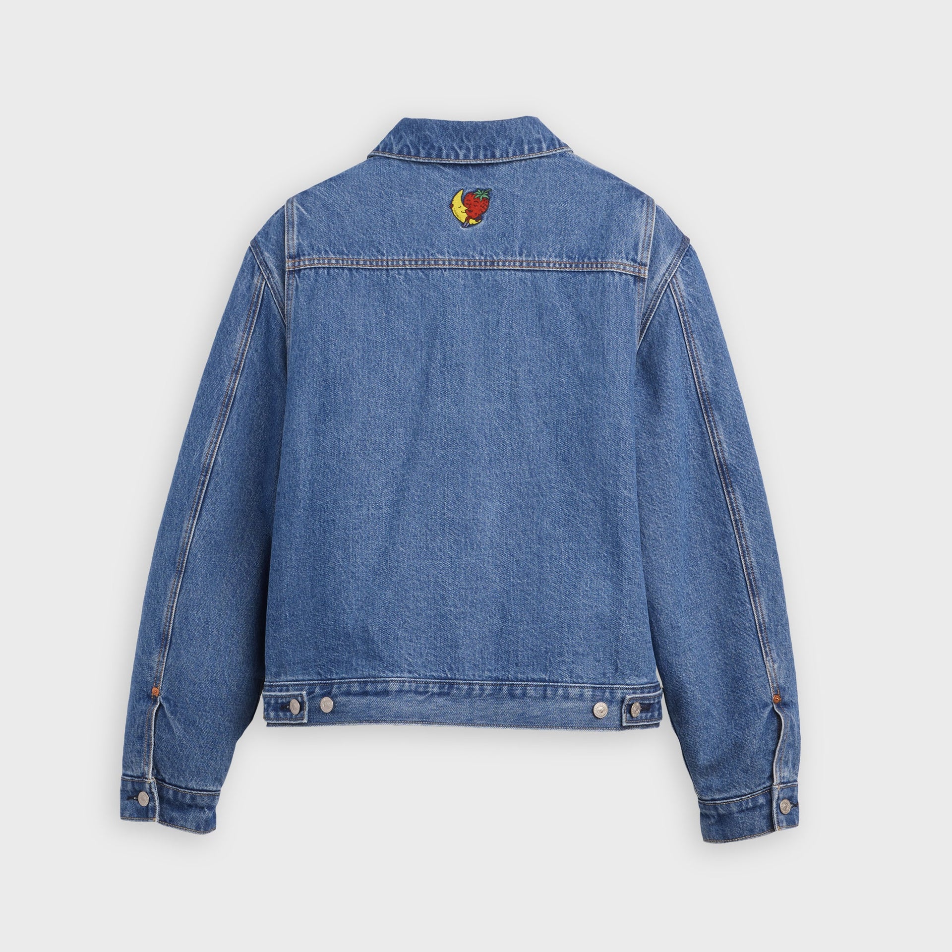 Back view of Levi's x Sky High Farm washed-blue trucker jacket with embroidered banana-and-strawberry mascot below the collar