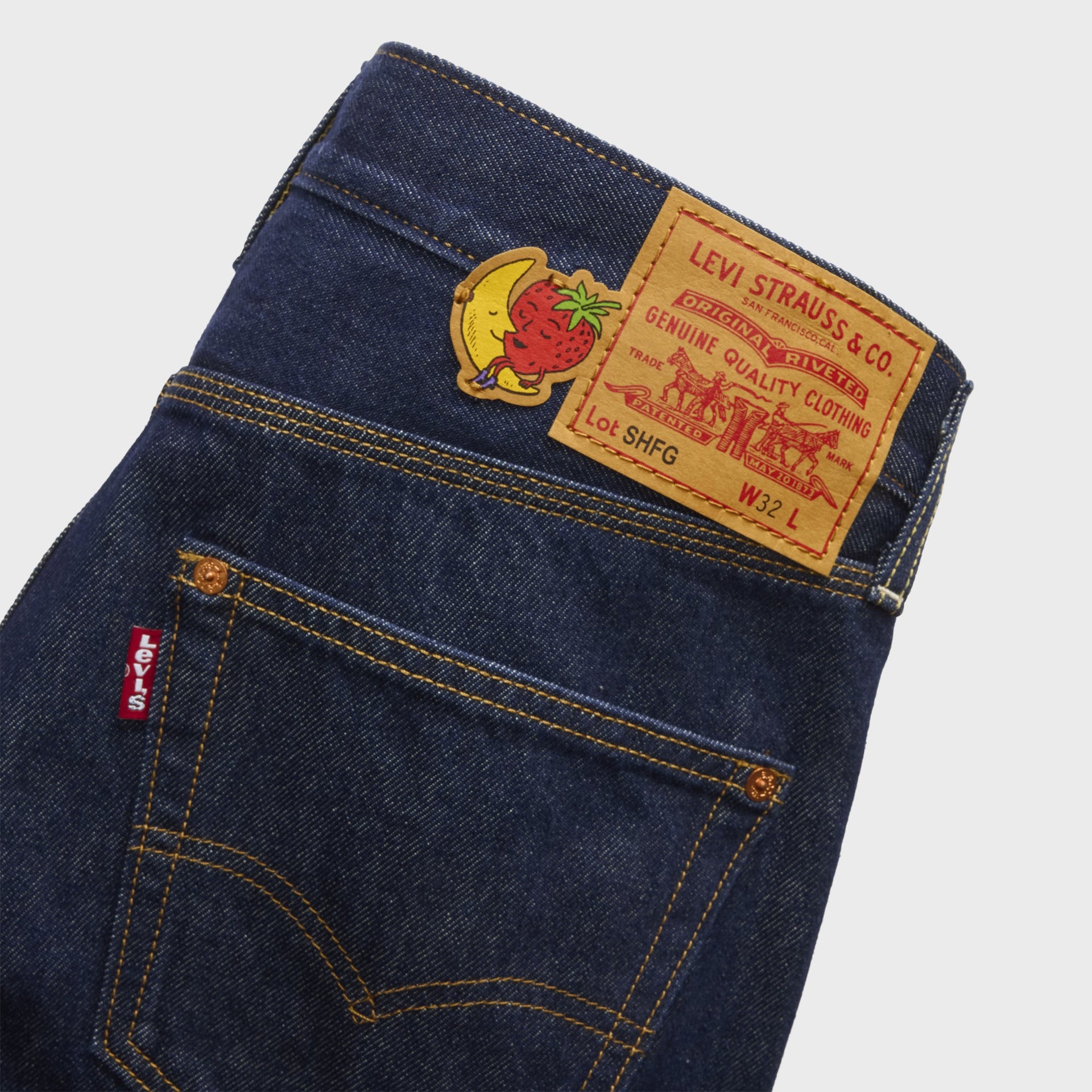 Close-up of Levi's x Sky High Farm loose jeans back pocket with leather 'SHFG' patch, mascot decal and red Levi's tab