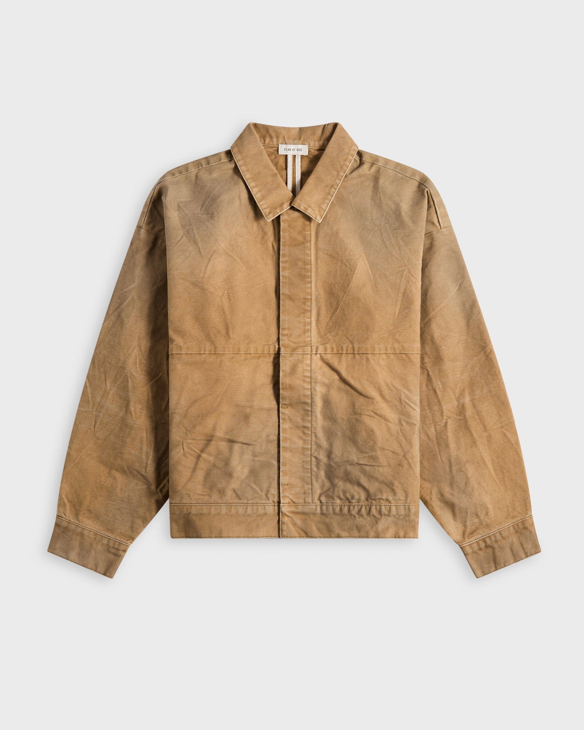 Fear of God tan waxed canvas chore jacket with a spread collar, flat-lay on a white background