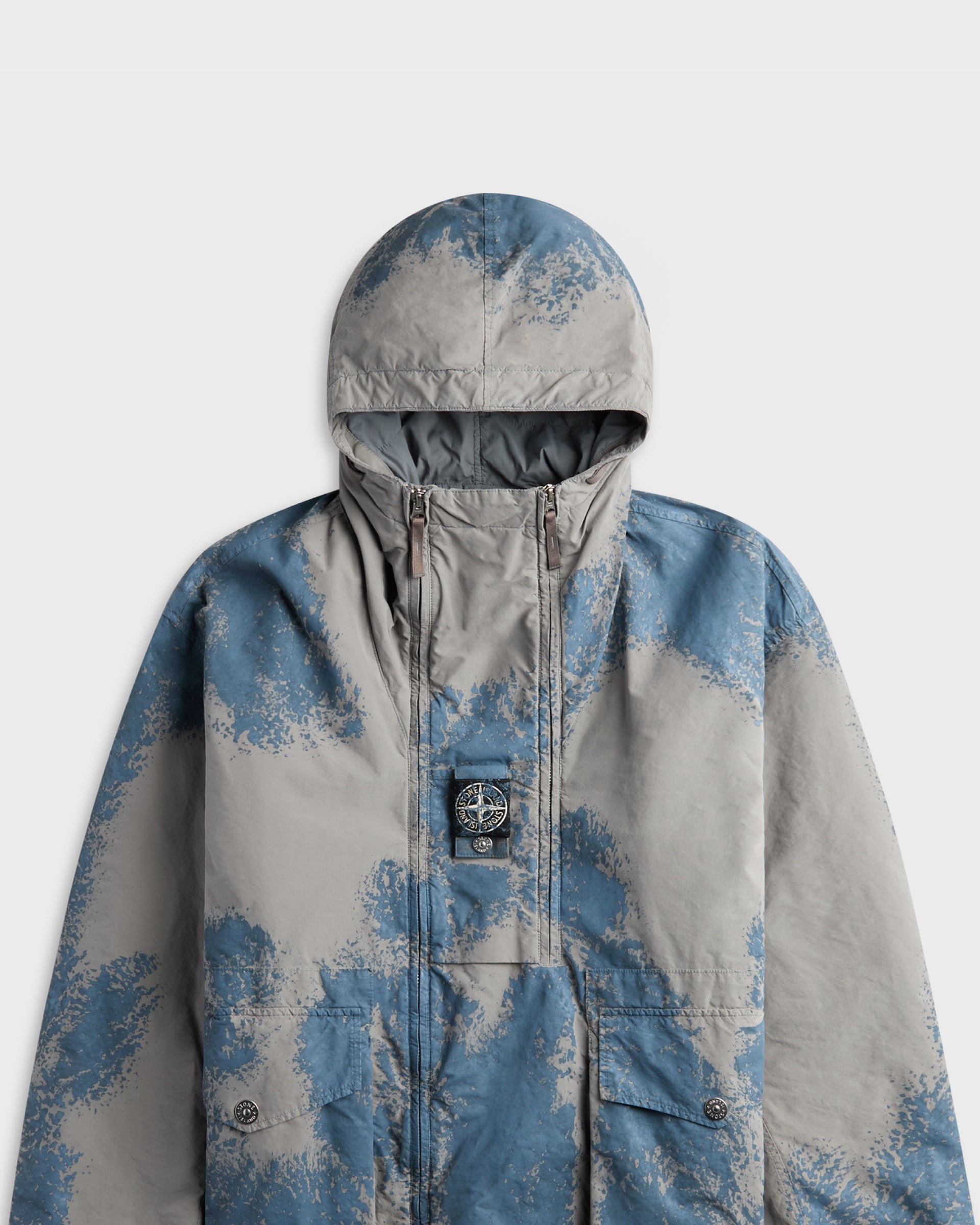 Stone Island grey and blue camouflage-print hooded jacket with logo patch, close-up front view
