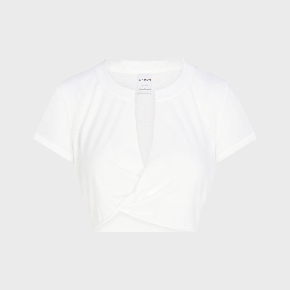 NikeSKIMS Performance Cotton Blend V-Neck Crop Top in Snow white, keyhole neckline with twisted front hem, flat lay