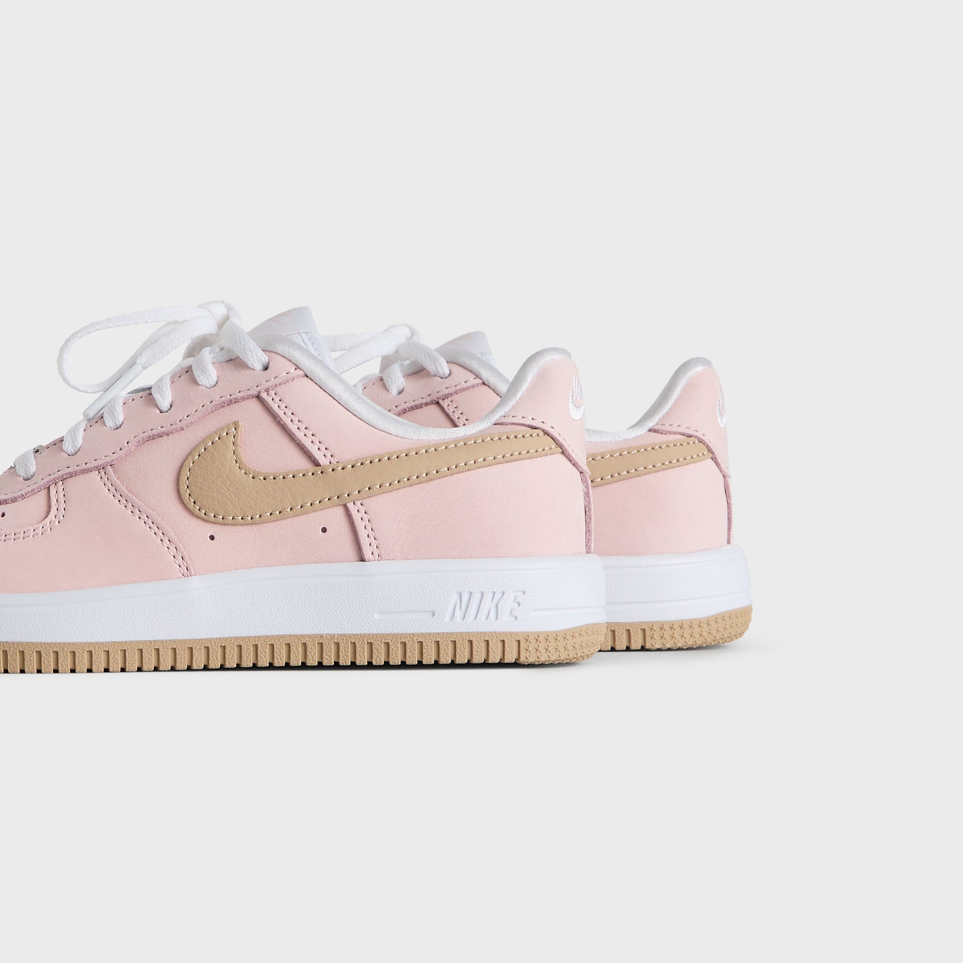 Kith Kids x Nike PS Air Force 1 Un-Linen pair viewed from the heel and outer side, pink leather on a gum sole