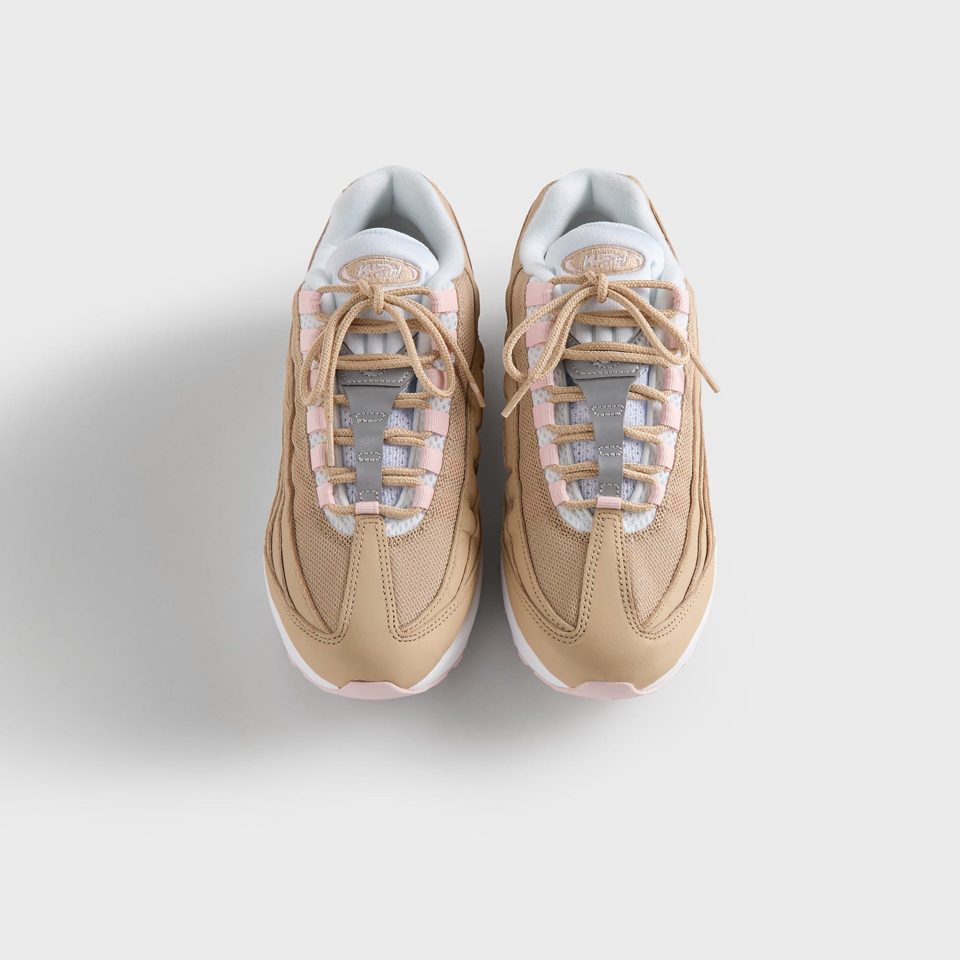 Close-up of the Kith Kids x Nike GS Air Max 95 Linen laced tongue, pink panels and light-blue lining (additional studio view)