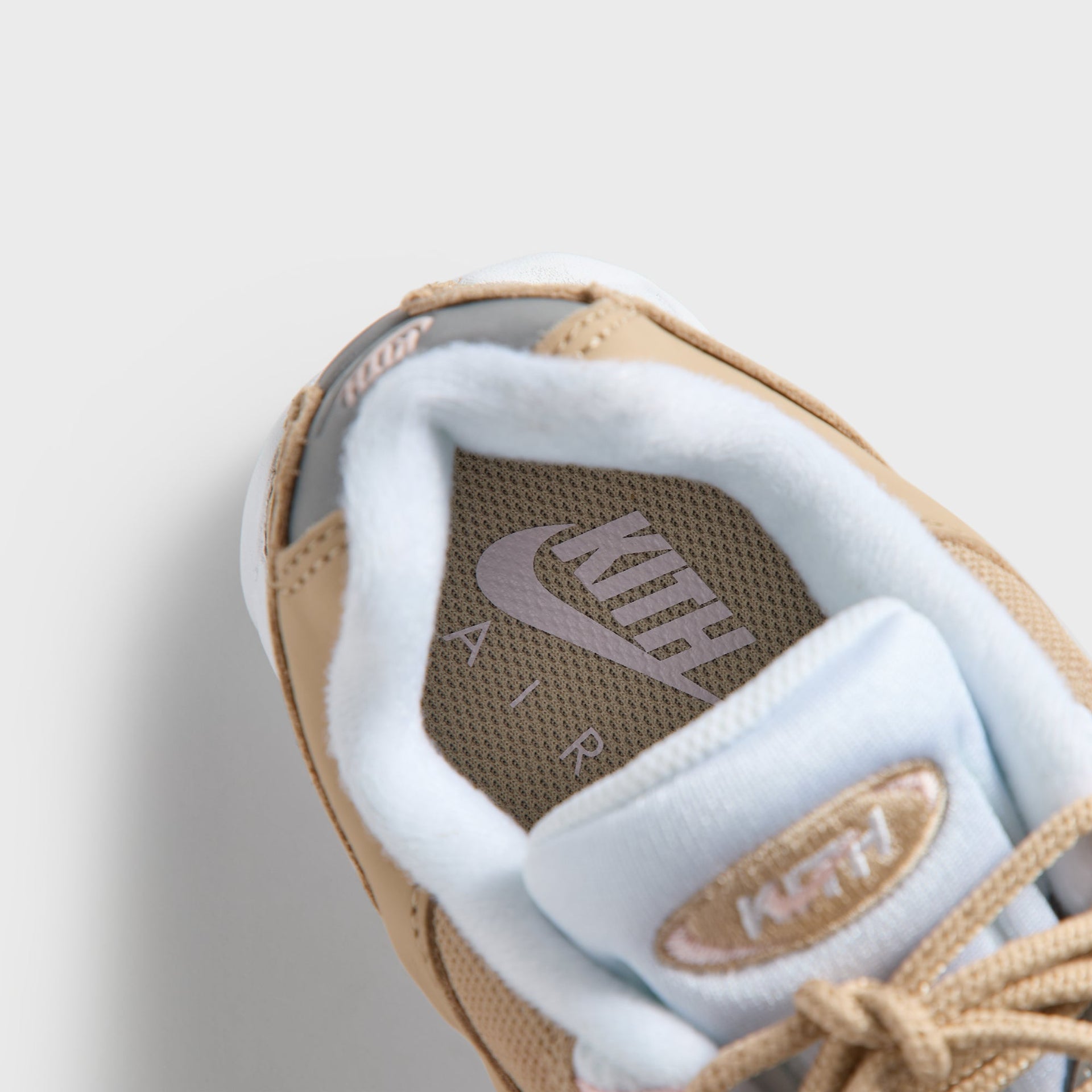Top-down close-up of the Kith Kids x Nike GS Air Max 95 Linen tongue, pink lace loops and wheat mesh (additional studio view)