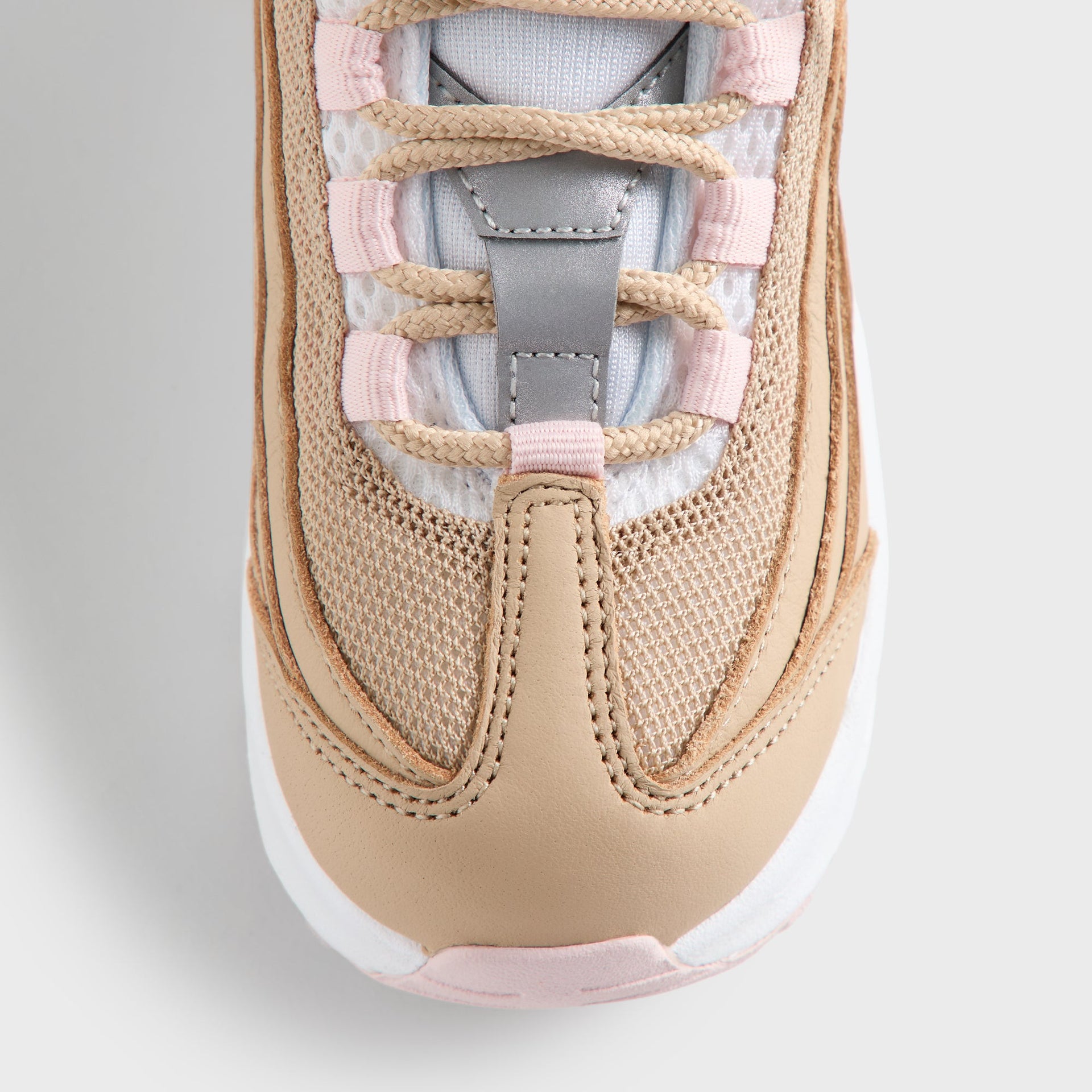 Close-up of the Kith Kids x Nike TD Air Max 95 Linen laced tongue, pink panels and light-blue lining (additional studio view)