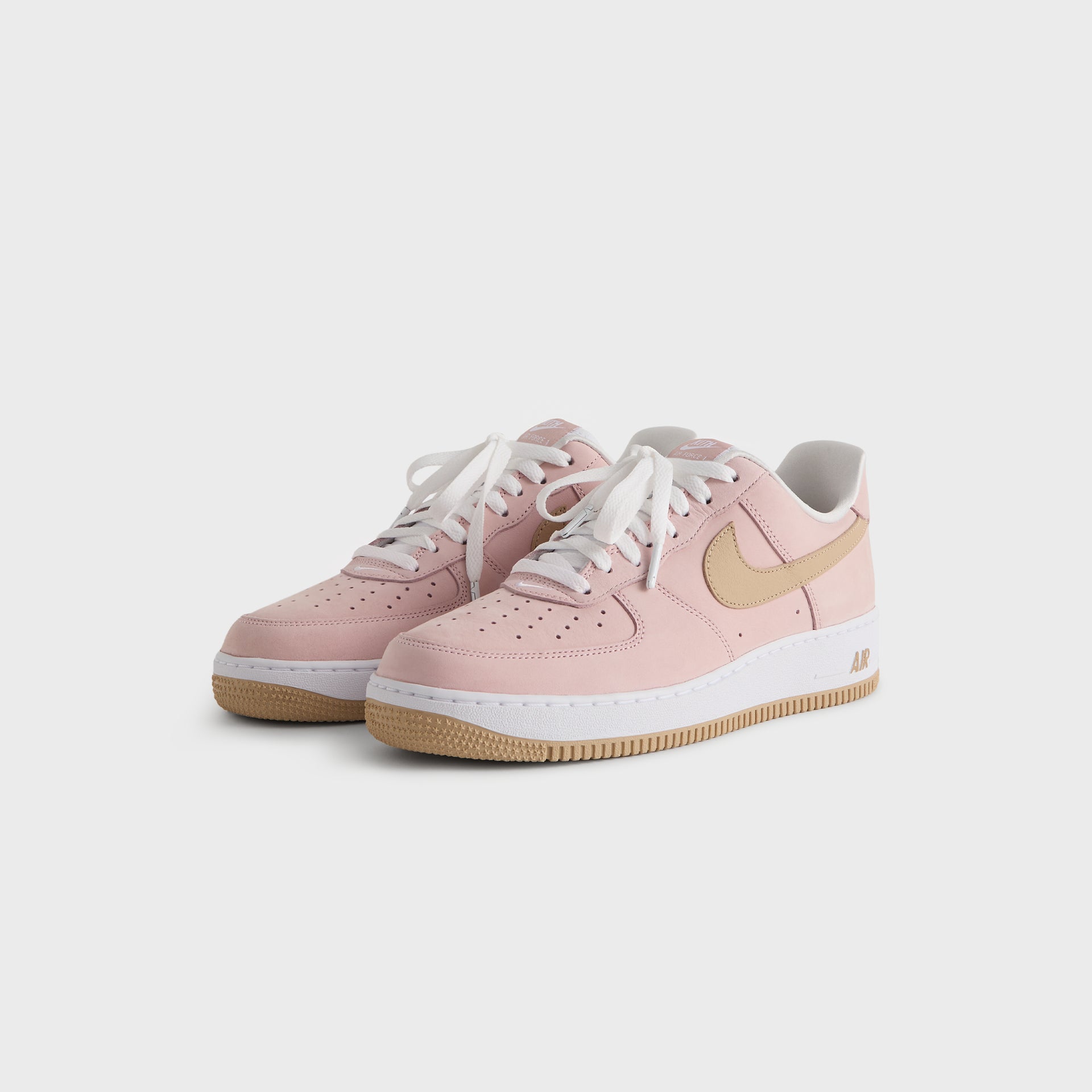 Kith x Nike Air Force 1 Un-Linen pair angled from the front, pink suede uppers, white laces and wheat Swoosh