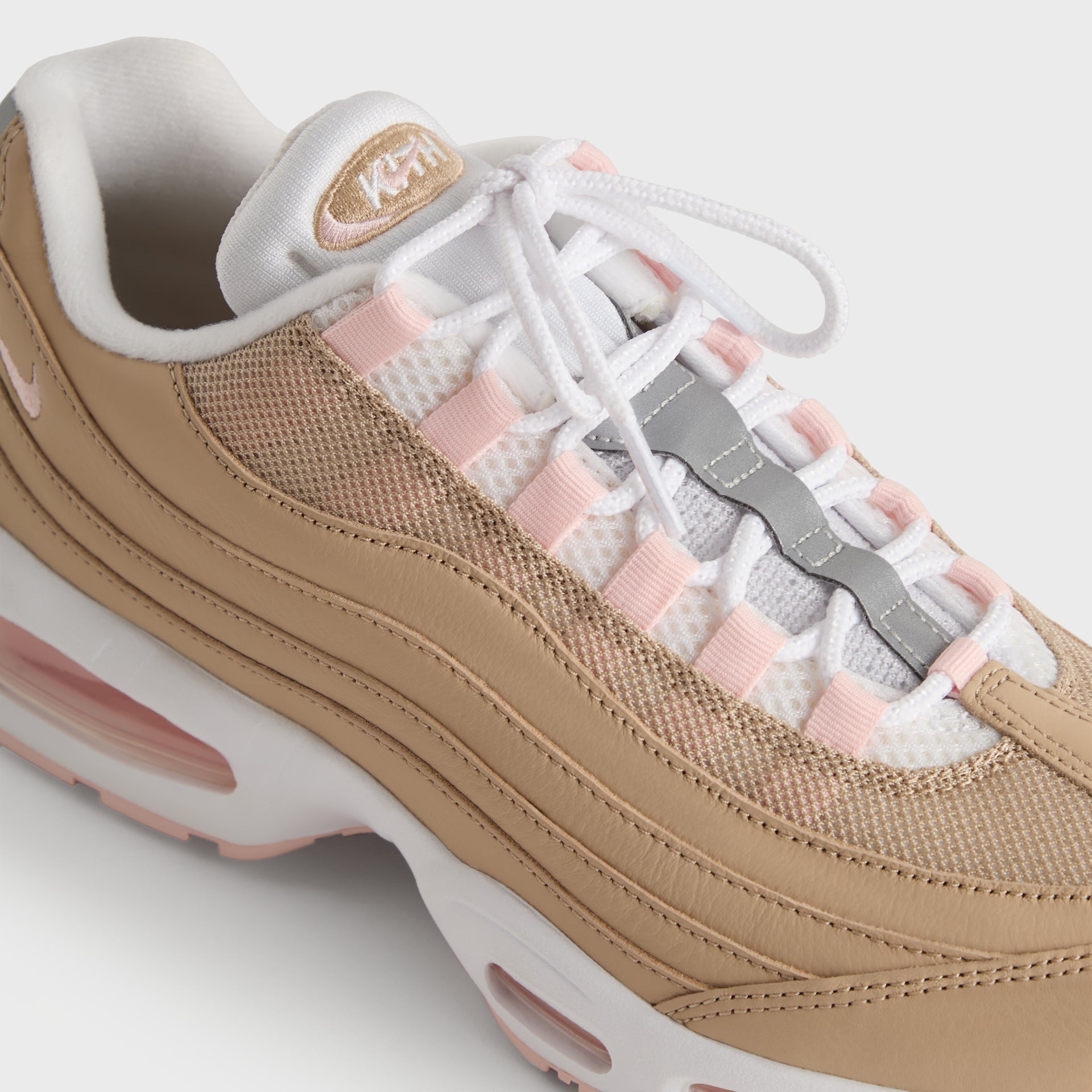 Three-quarter toe close-up of the Kith x Nike Air Max 95 Linen, pink lace panels and wheat mesh