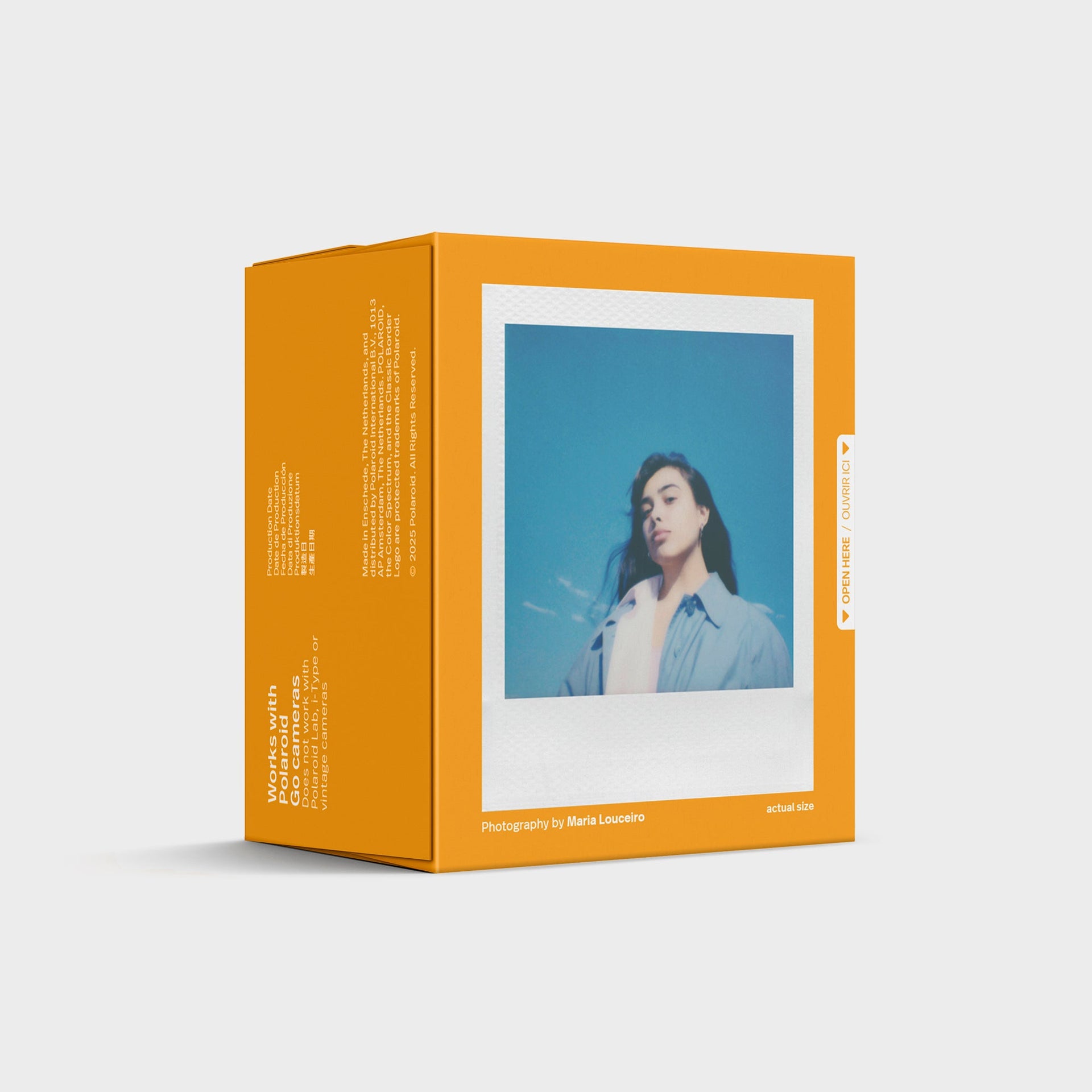 Back of Polaroid Go Color Film pack in orange, works-with-Go note and a sample instant portrait against blue sky