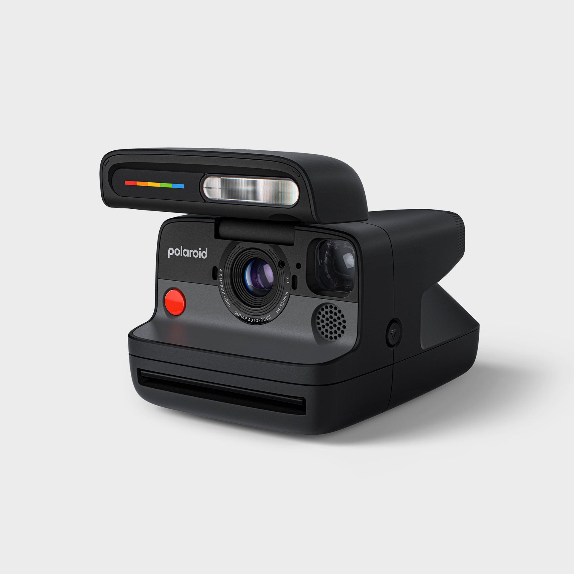 Polaroid Flip black instant camera at a three-quarter angle, flash raised, showing its tapered body and rainbow accent