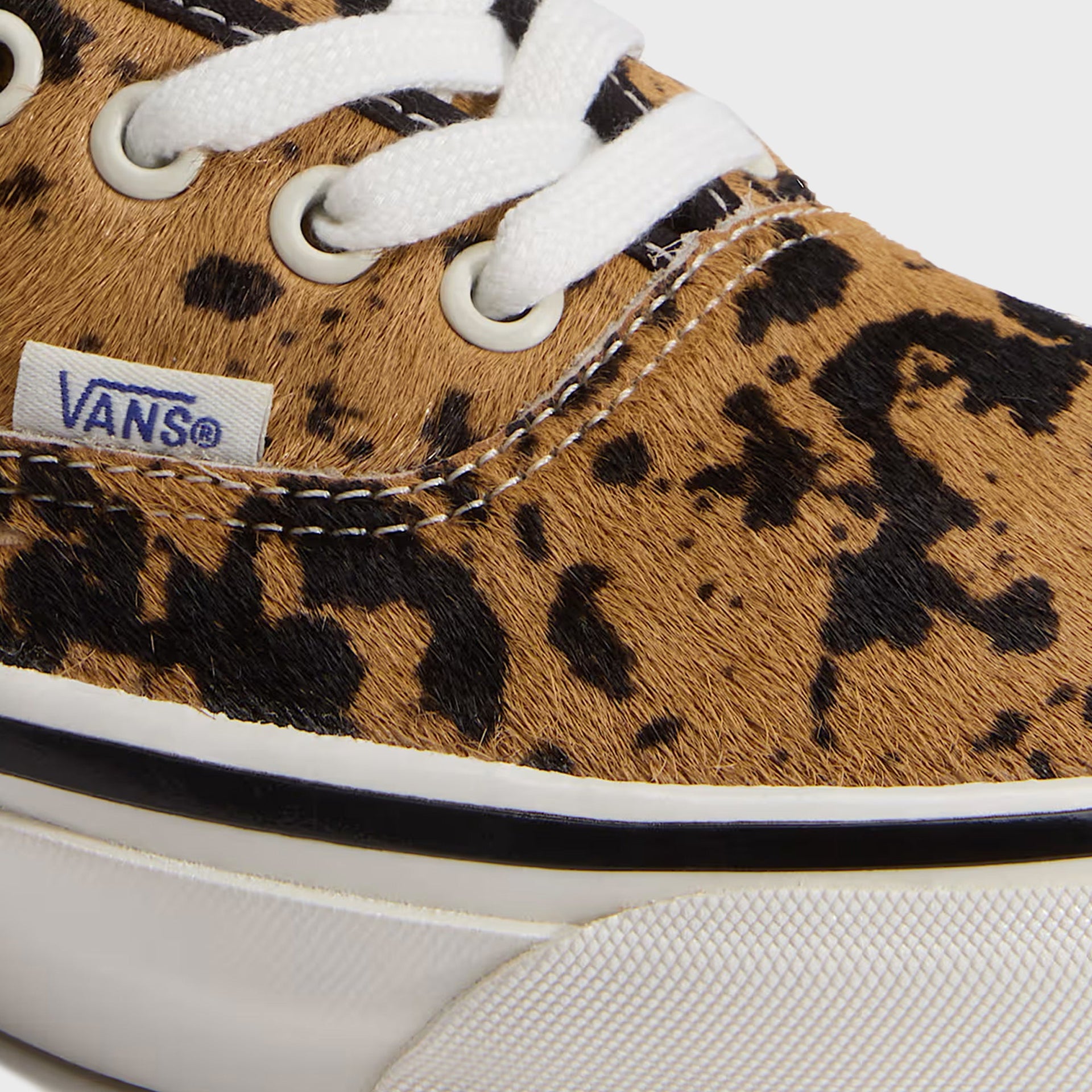 Close-up of VANS LX Authentic 44 cow-print calf hair upper showing eyelets, laces and woven Vans label