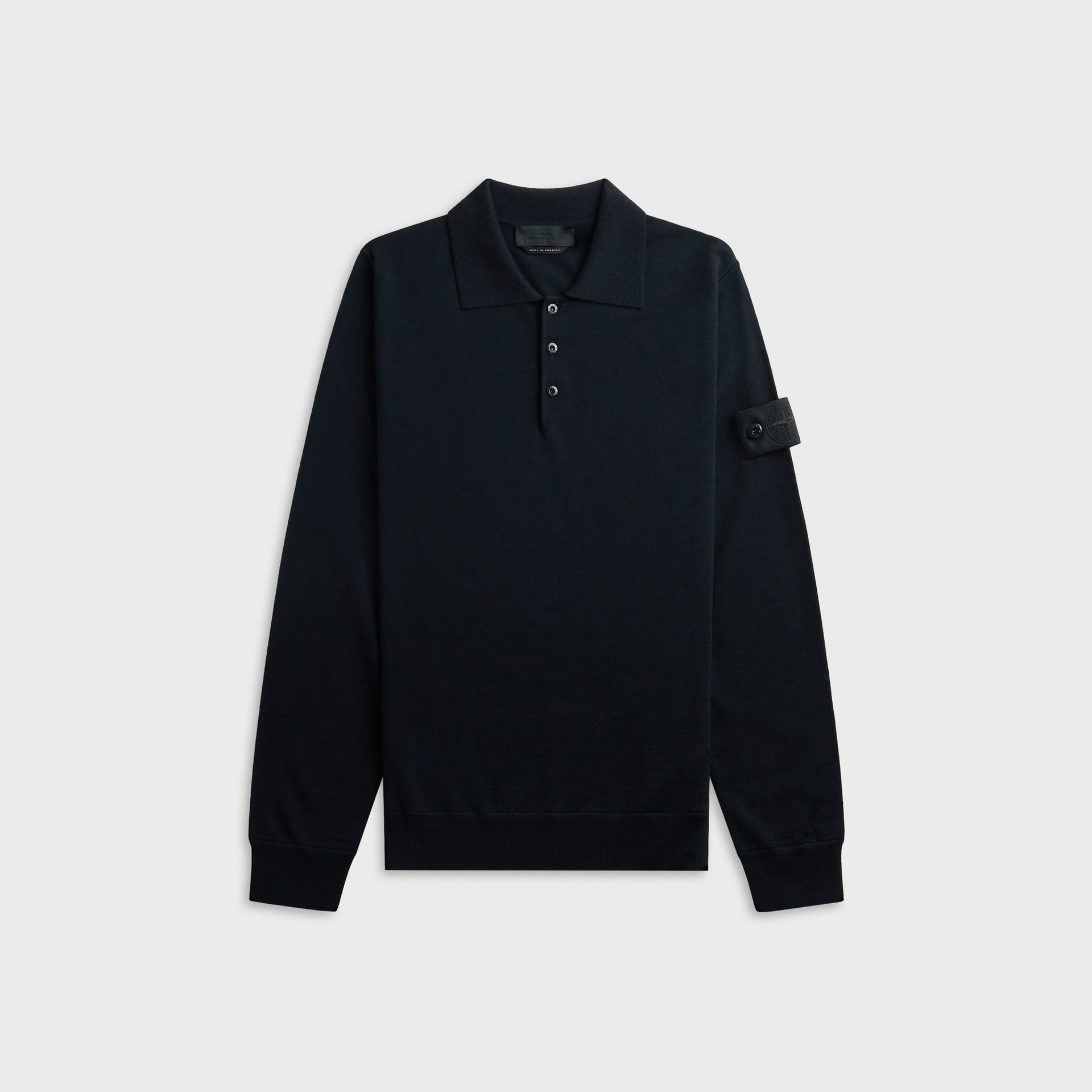 Stone Island long-sleeve knit polo shirt in navy, front view with three-button placket and sleeve badge