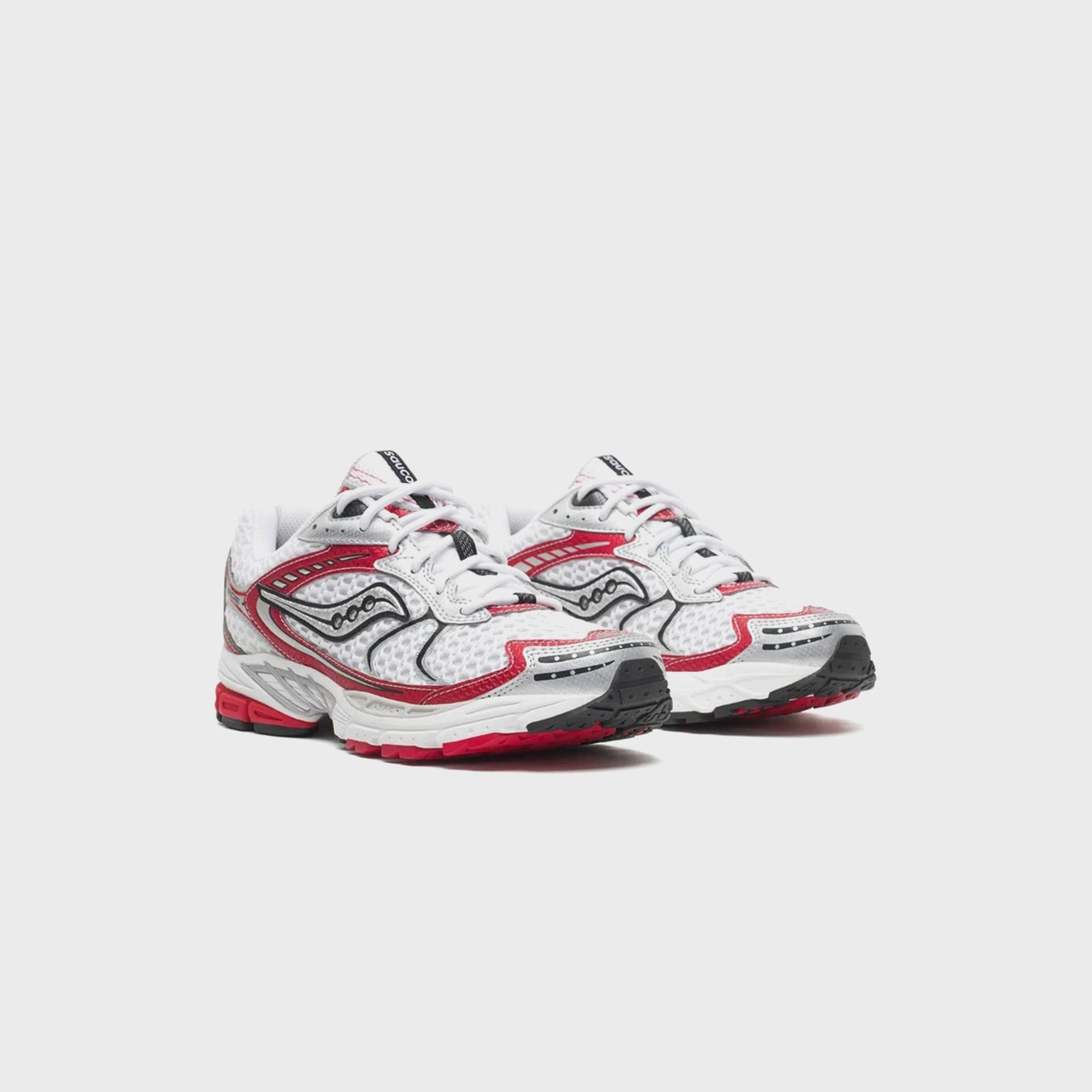 Pair of Saucony Progrid Ride 1 running shoes in white with racing red accents, front three-quarter view