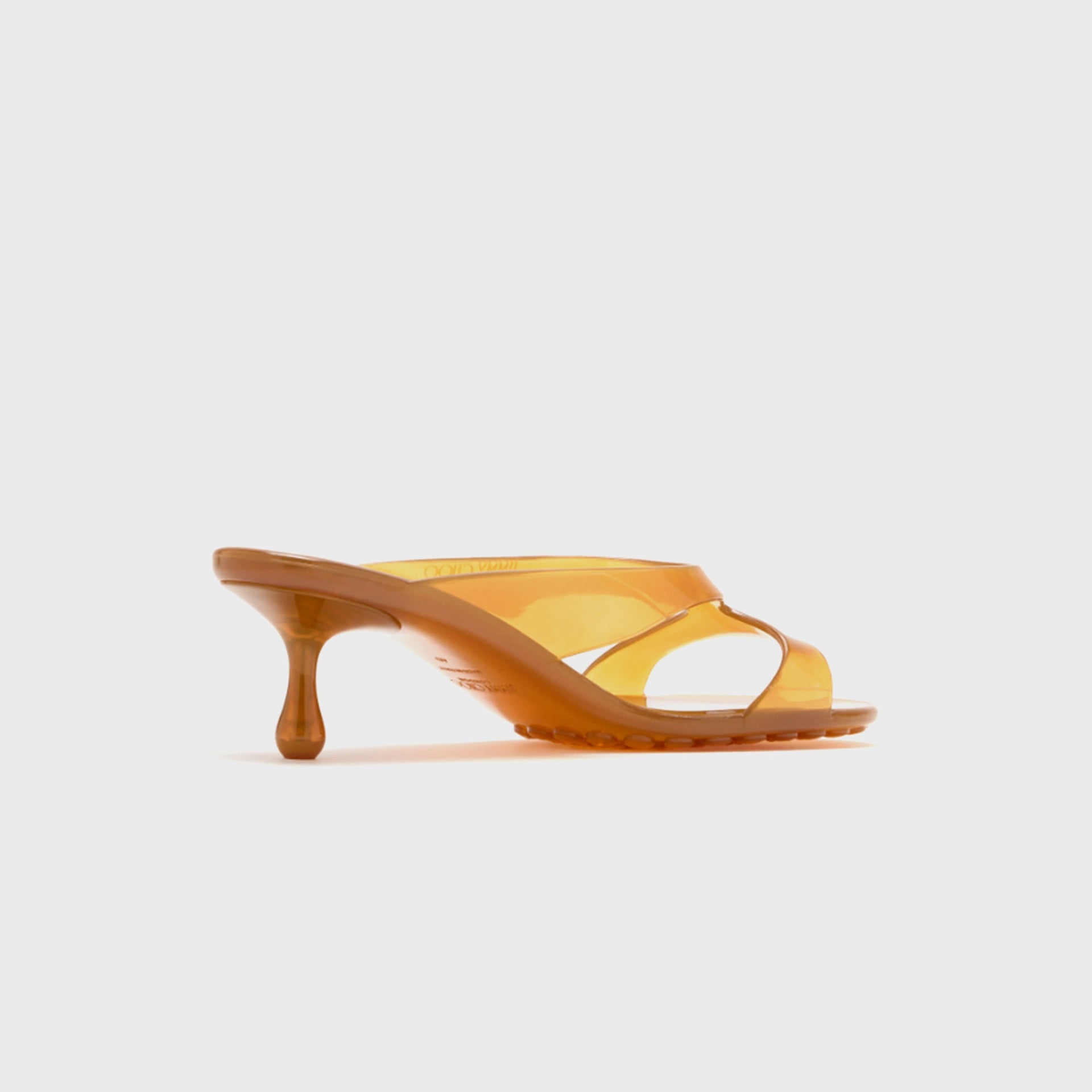 Jimmy Choo Jelly Drop 50 mule sandal in translucent amber jelly, medial view showing Jimmy Choo branding on footbed