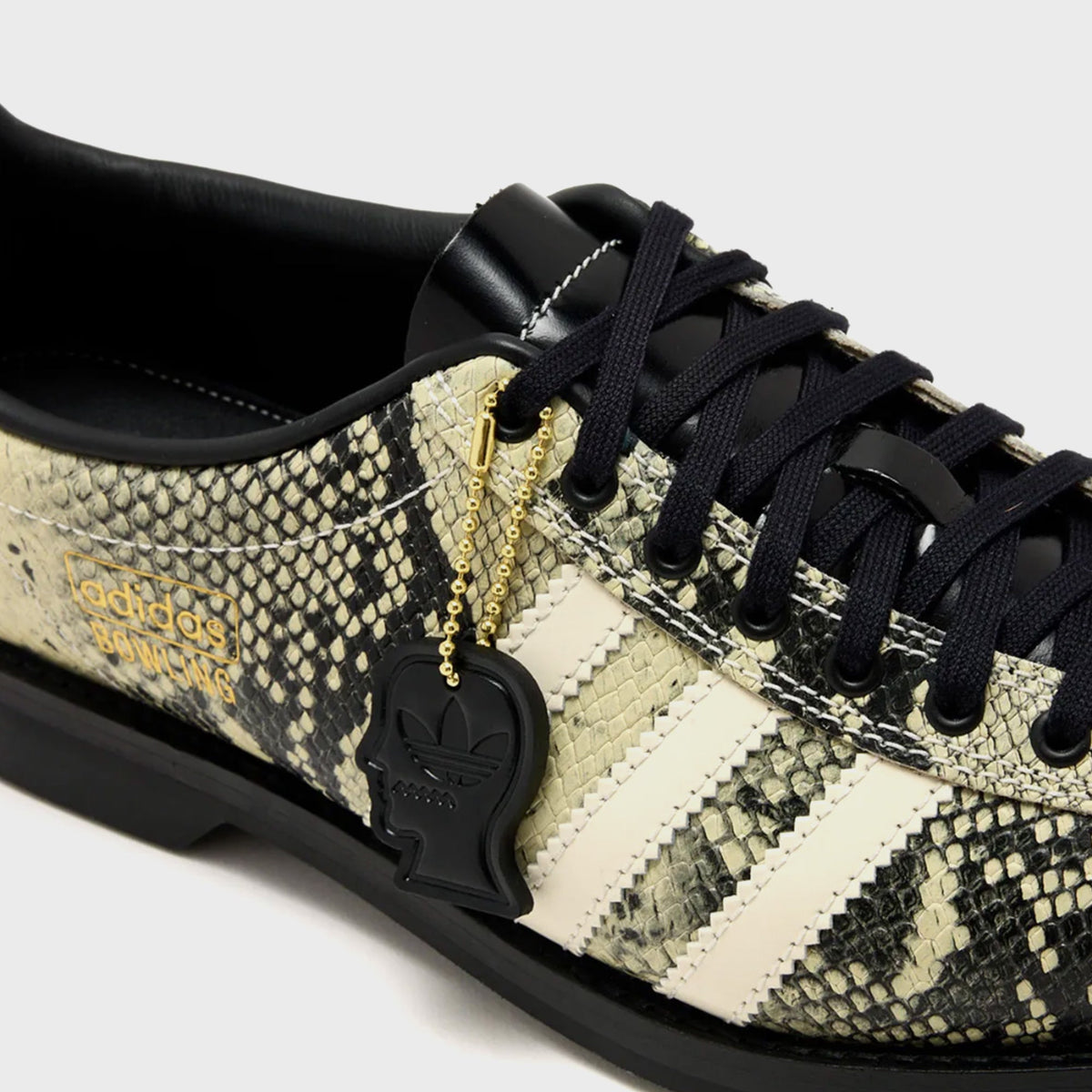 adidas x Brain Dead Samba Bowling shoe in Multi Color / Cream White / Core Black snakeskin-print leather, close-up of laces, cream stripes and black head-shaped charm