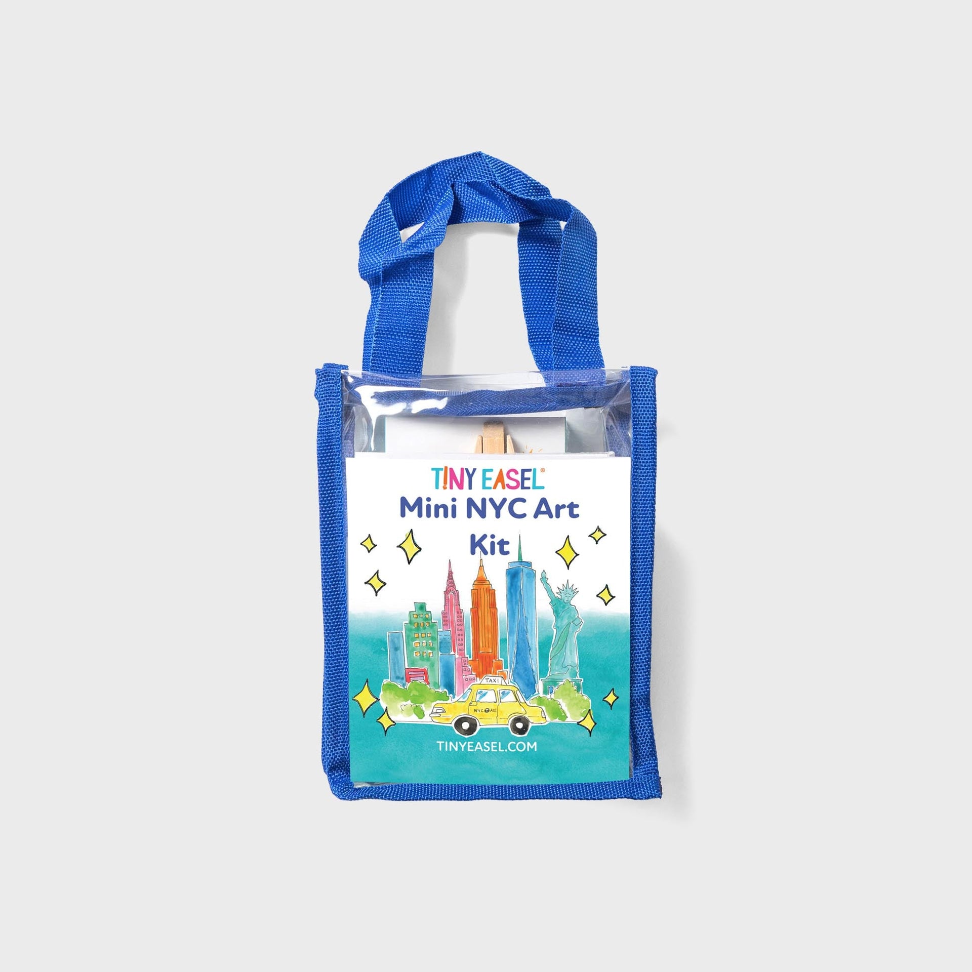 Tiny Easel Mini NYC Art Kit in clear blue-trimmed tote, watercolor skyline with Statue of Liberty and yellow taxi