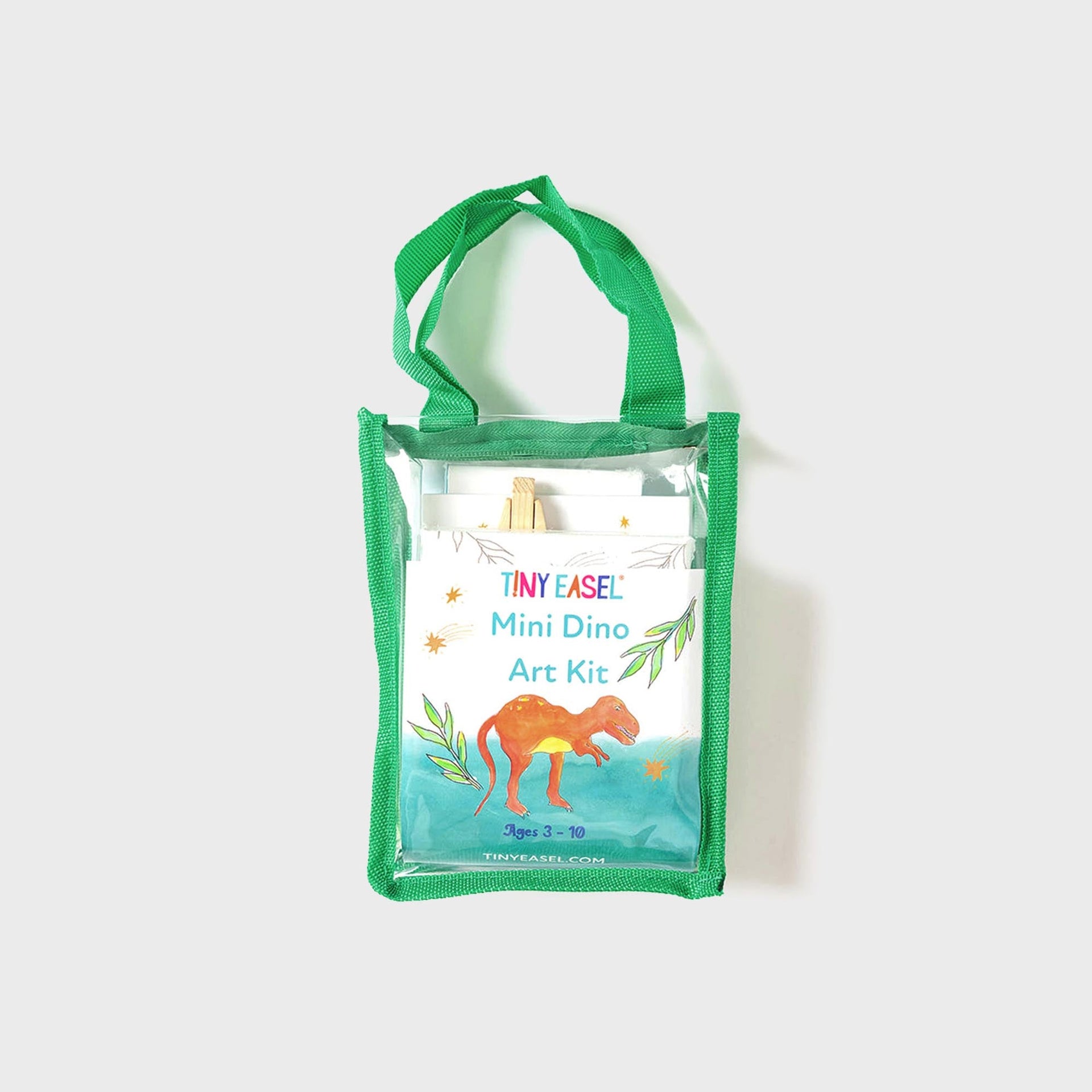 Tiny Easel Mini Dino Art Kit in clear PVC mini tote with green trim, front view of watercolor T-rex packaging, ages 3-10